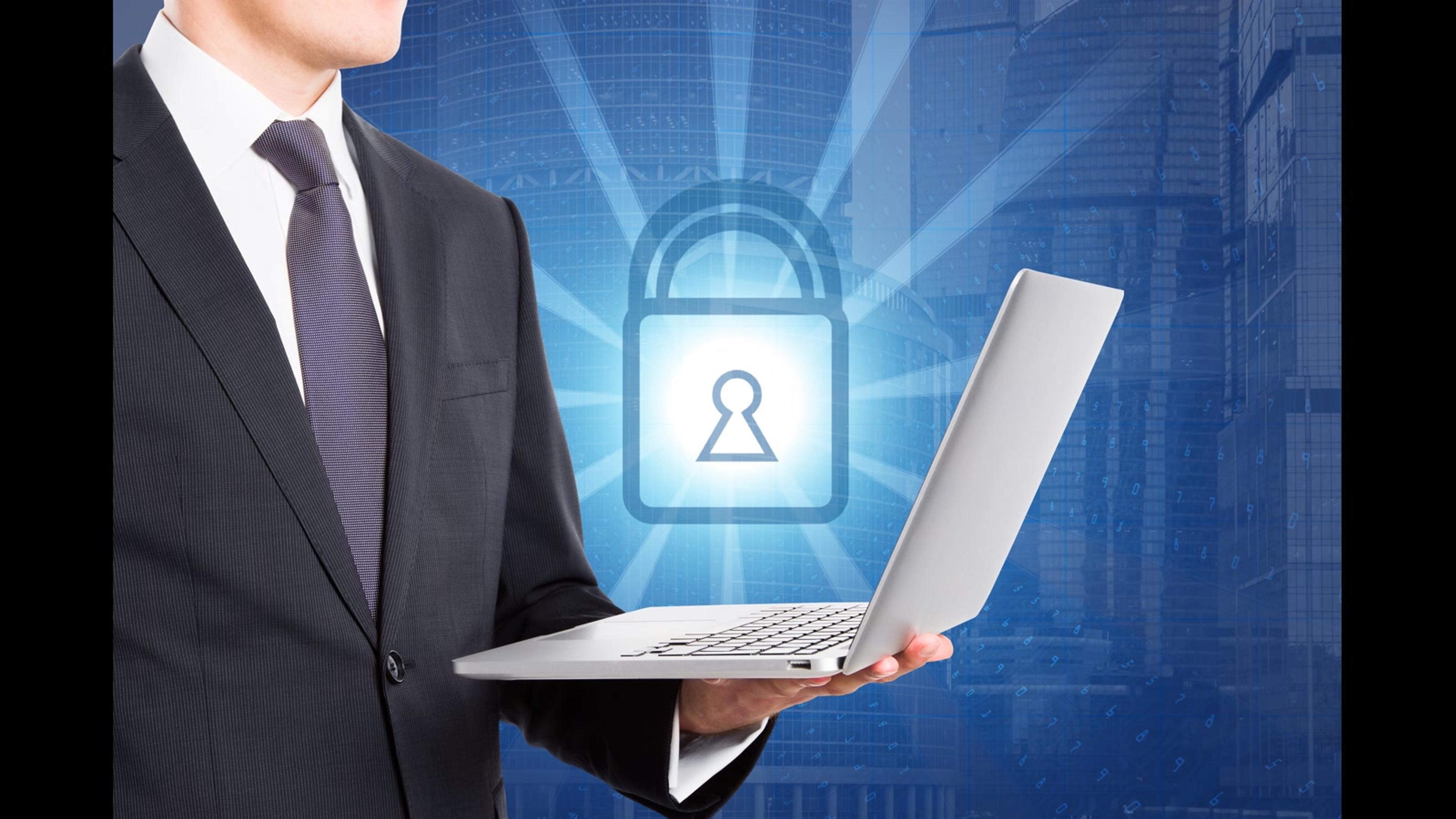 Business professional holding a laptop with a padlock graphic — securing company endpoints against malware