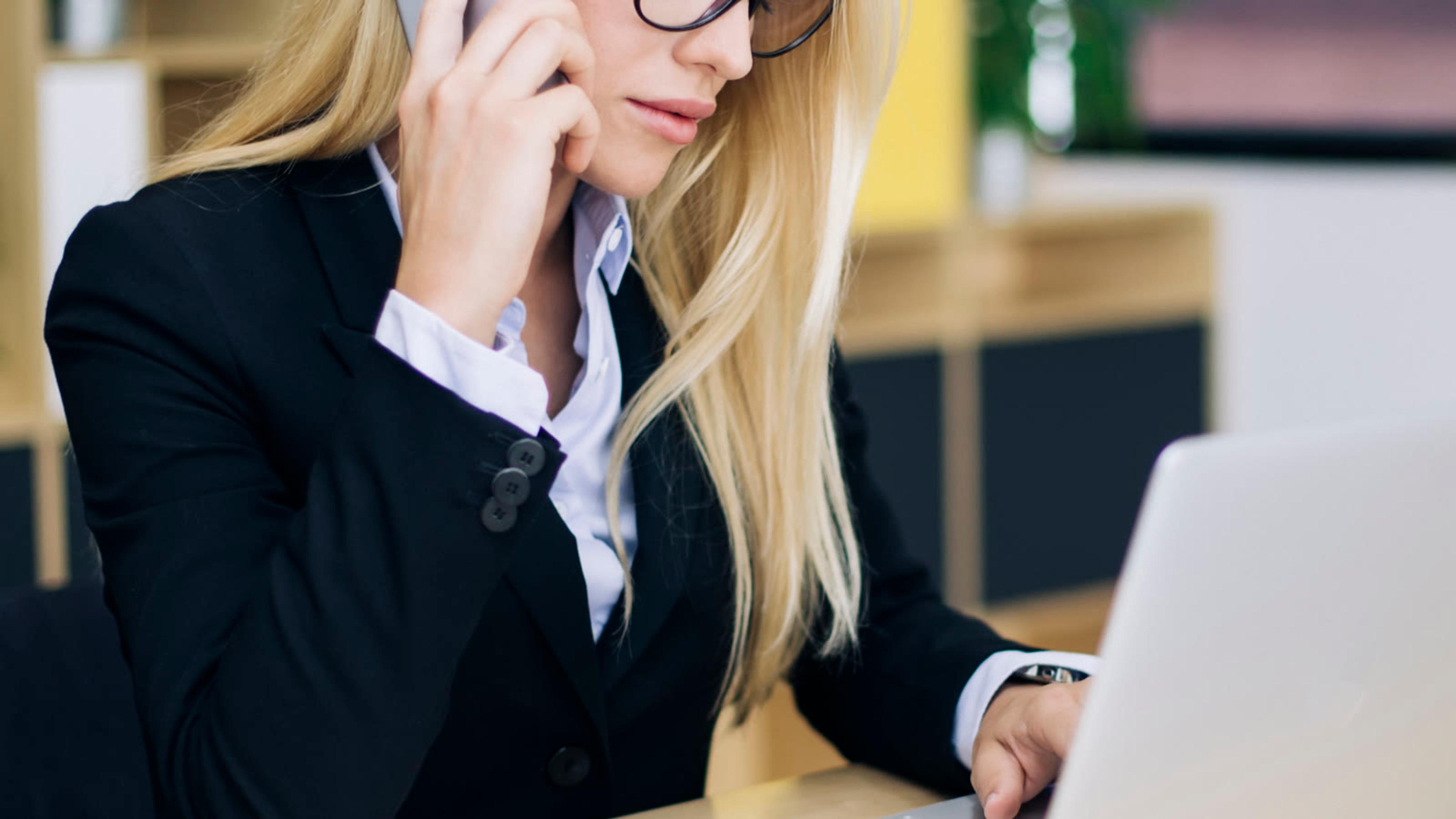 Professional on a business phone call while working at a laptop
