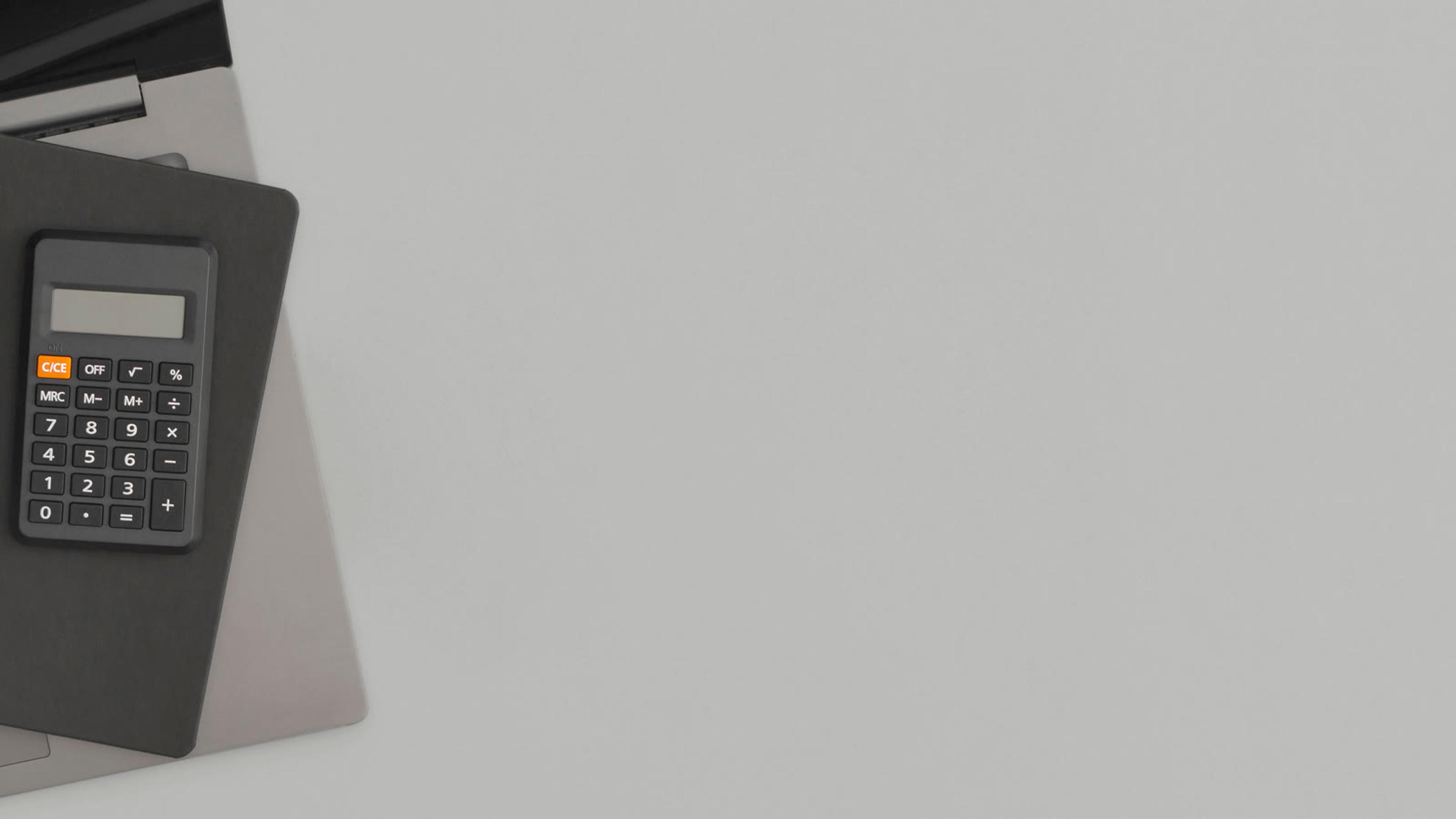Calculator and notepad on a laptop for reviewing phone-system requirements