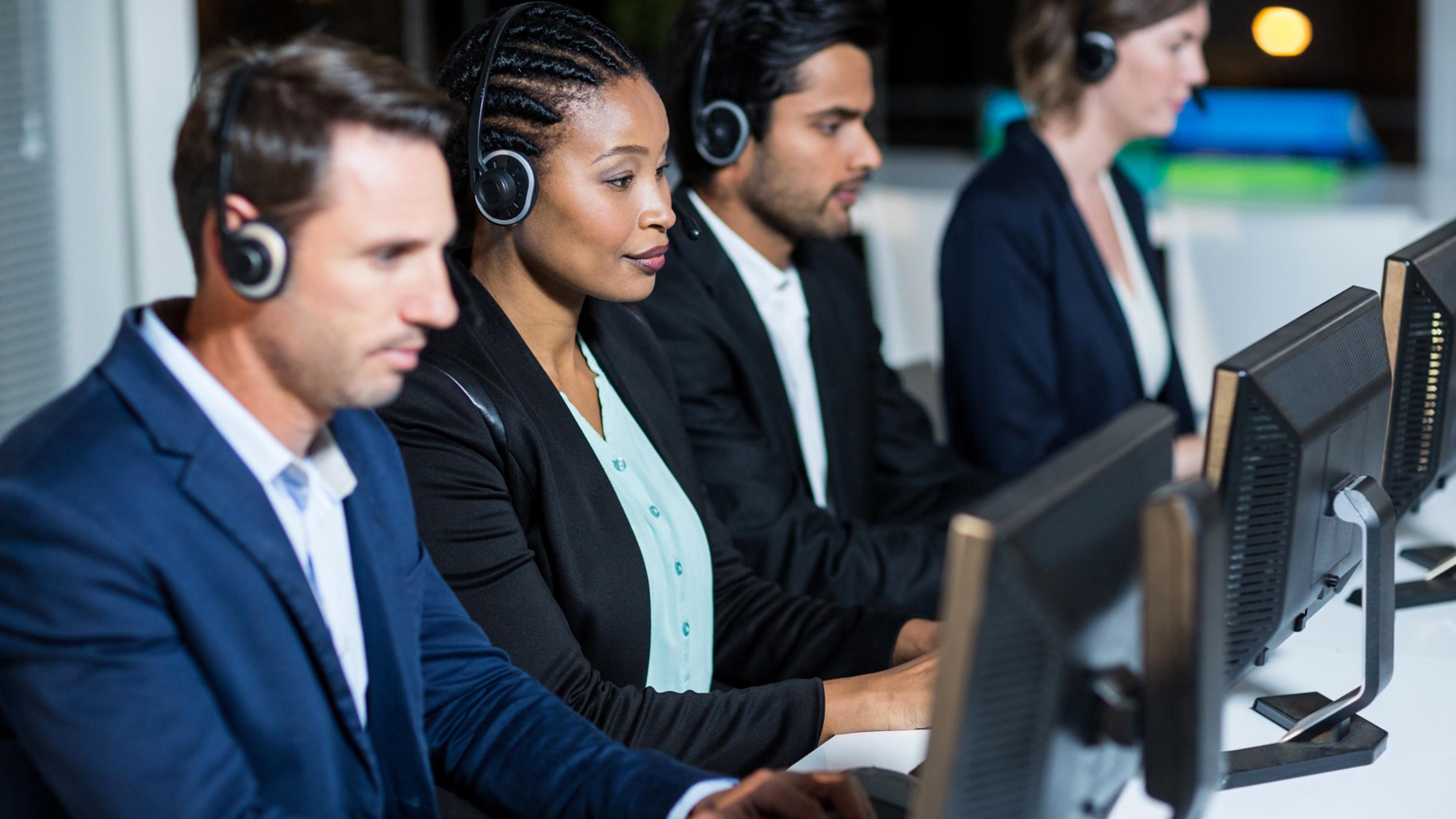 Contact center agents wearing headsets working at computers