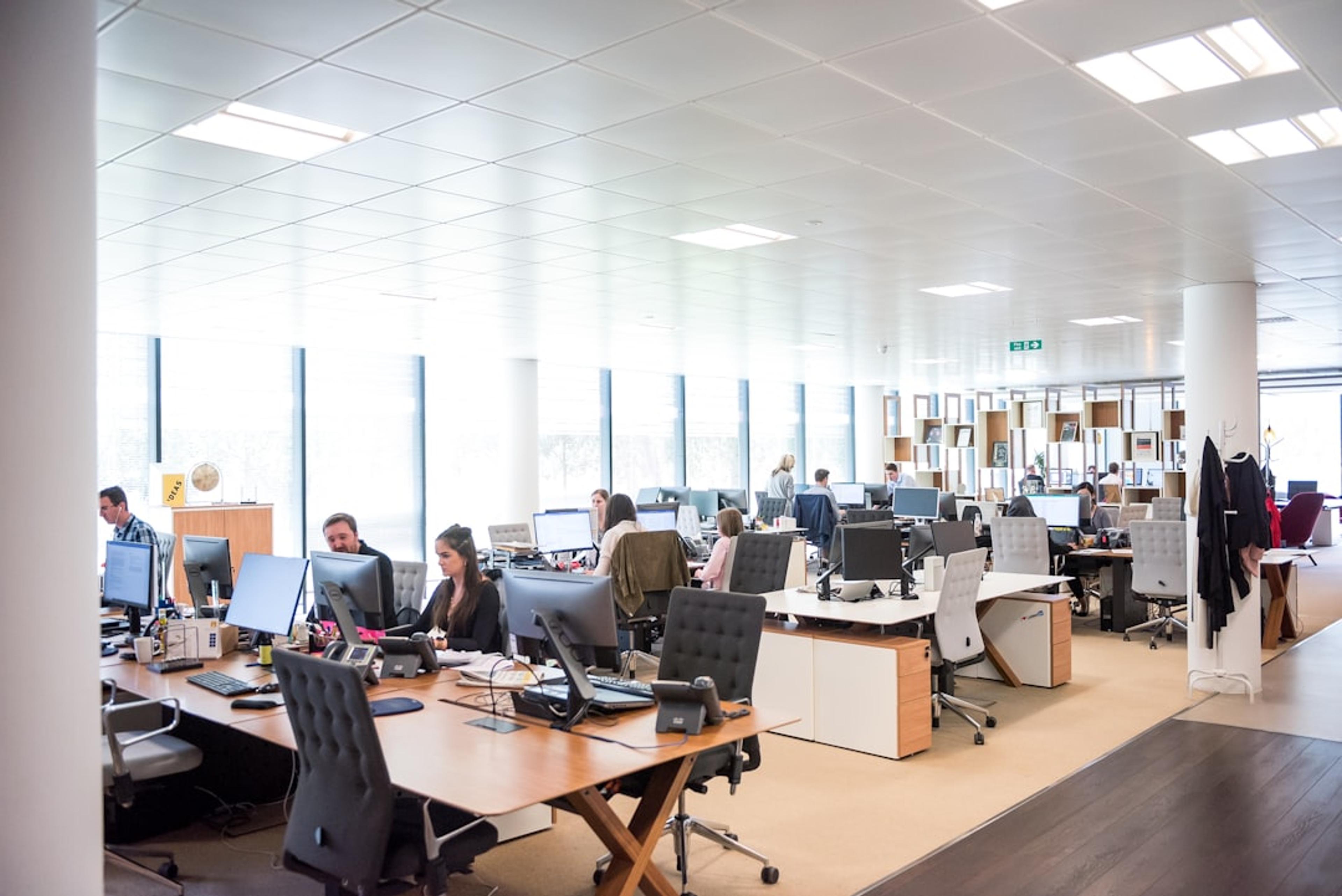 Open office team working at desks with communications tools