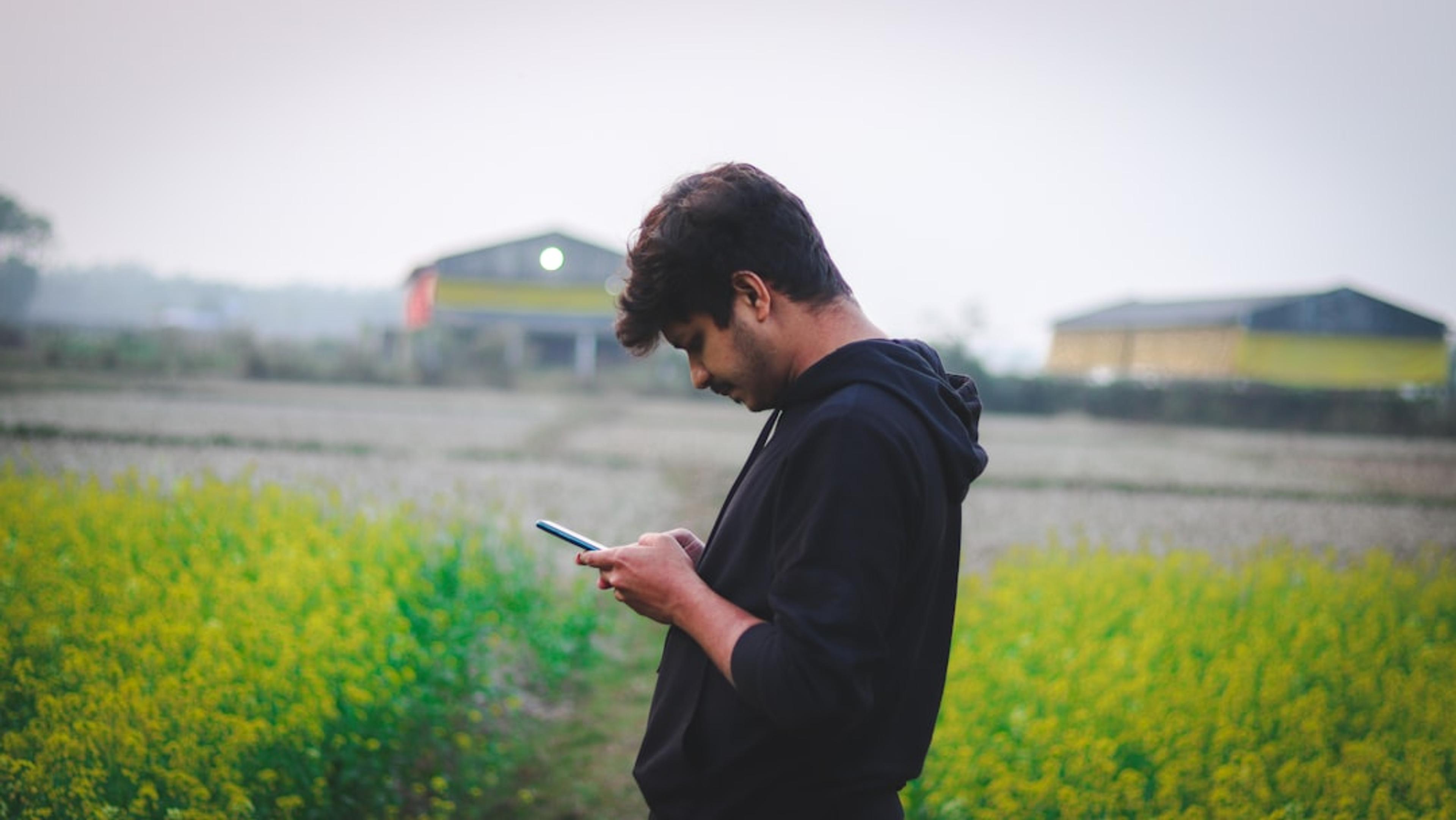 Field worker checking a smartphone outside mobile coverage areas
