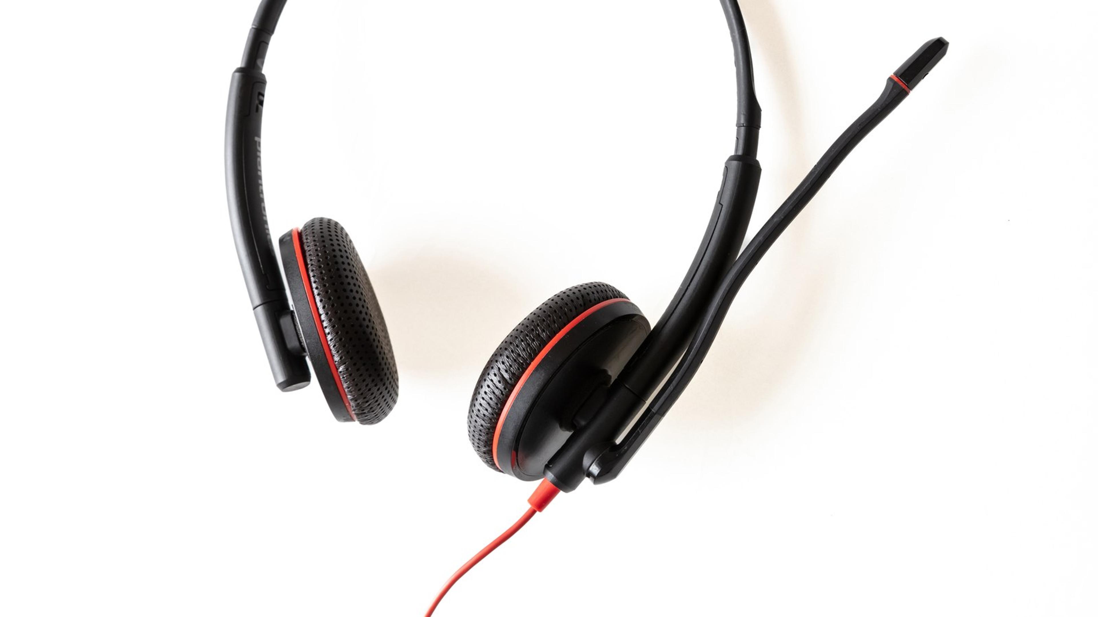 Black headset with boom microphone on white background — softphone headset gear for branded SIP apps