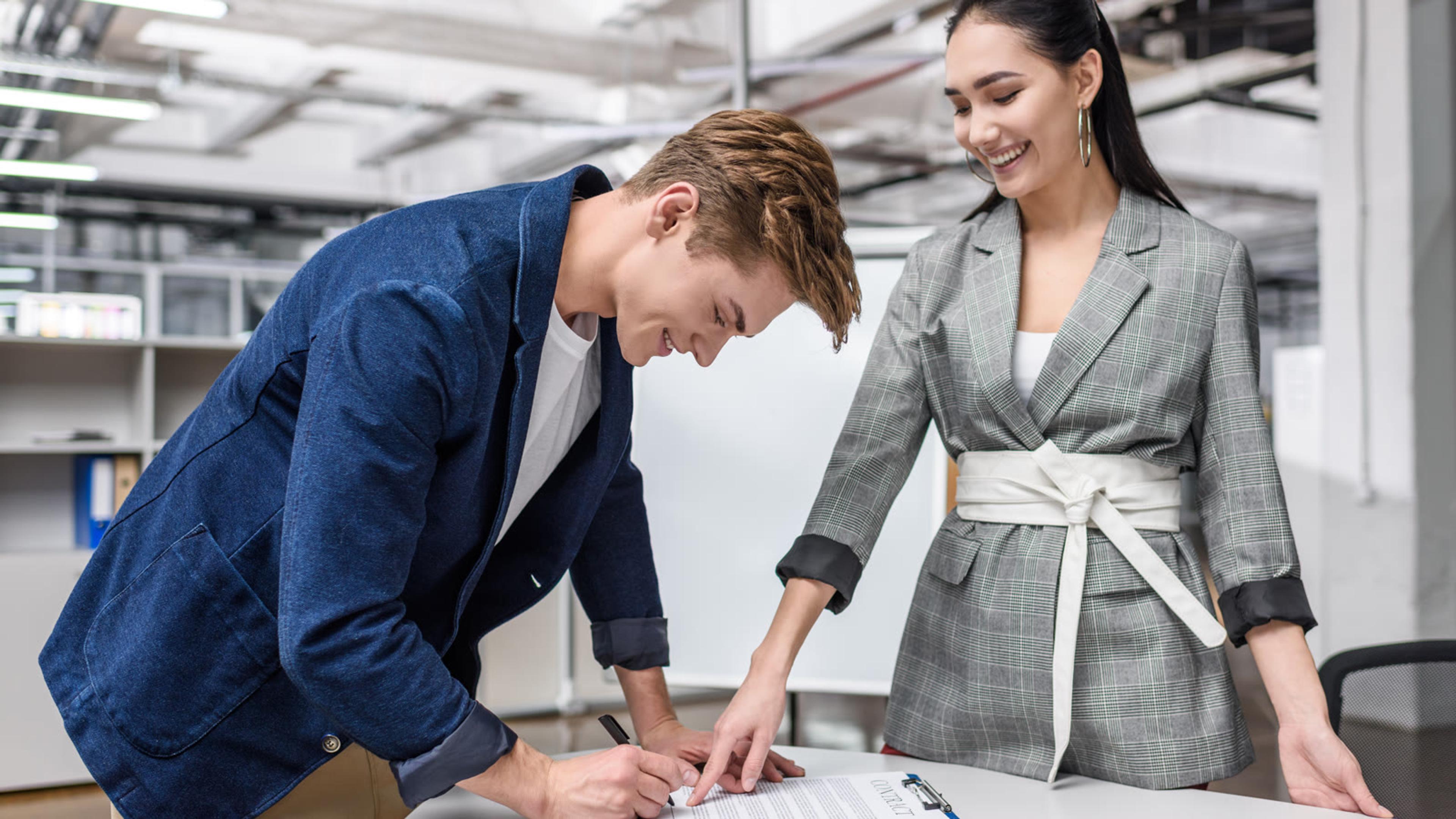 System owner signing off an access review document while a colleague looks on in the office