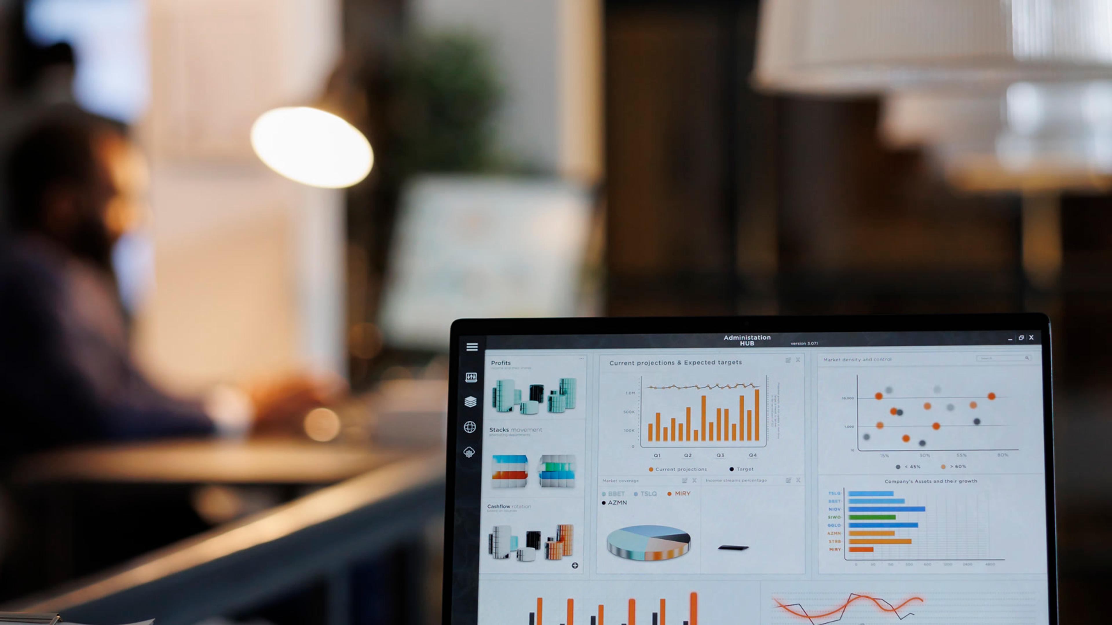 Open laptop showing analytics charts in a modern office — SaaS administration and license usage analysis