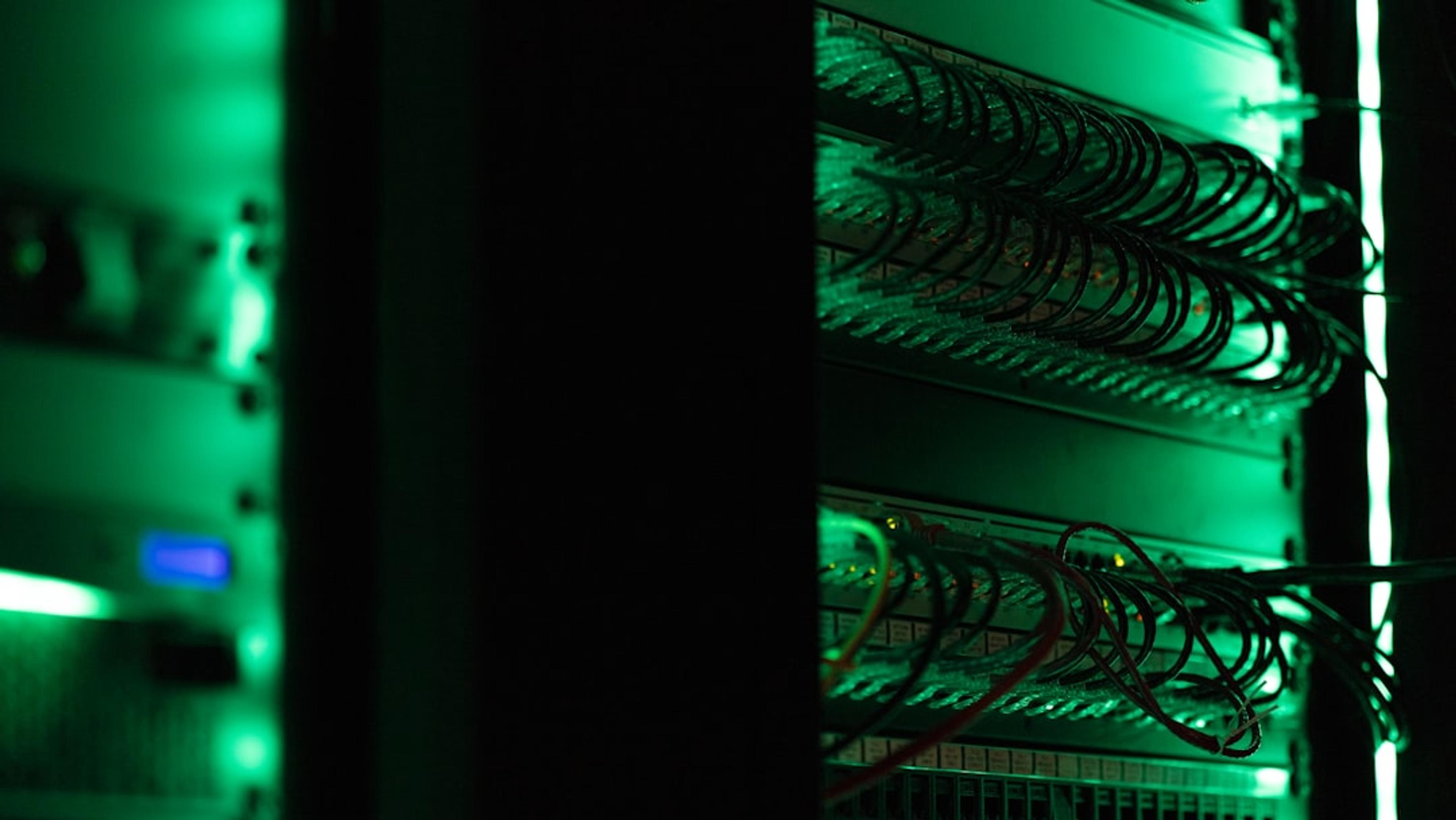 Server rack with network equipment and green indicator lights in a data center