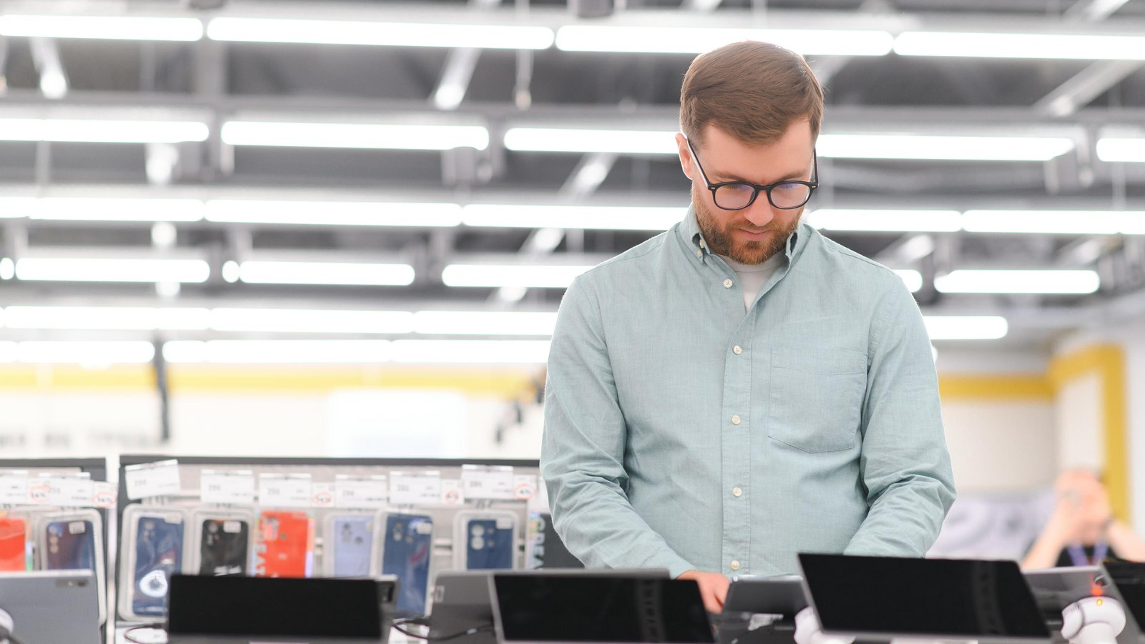Person checking a row of tablets and phones on a device display
