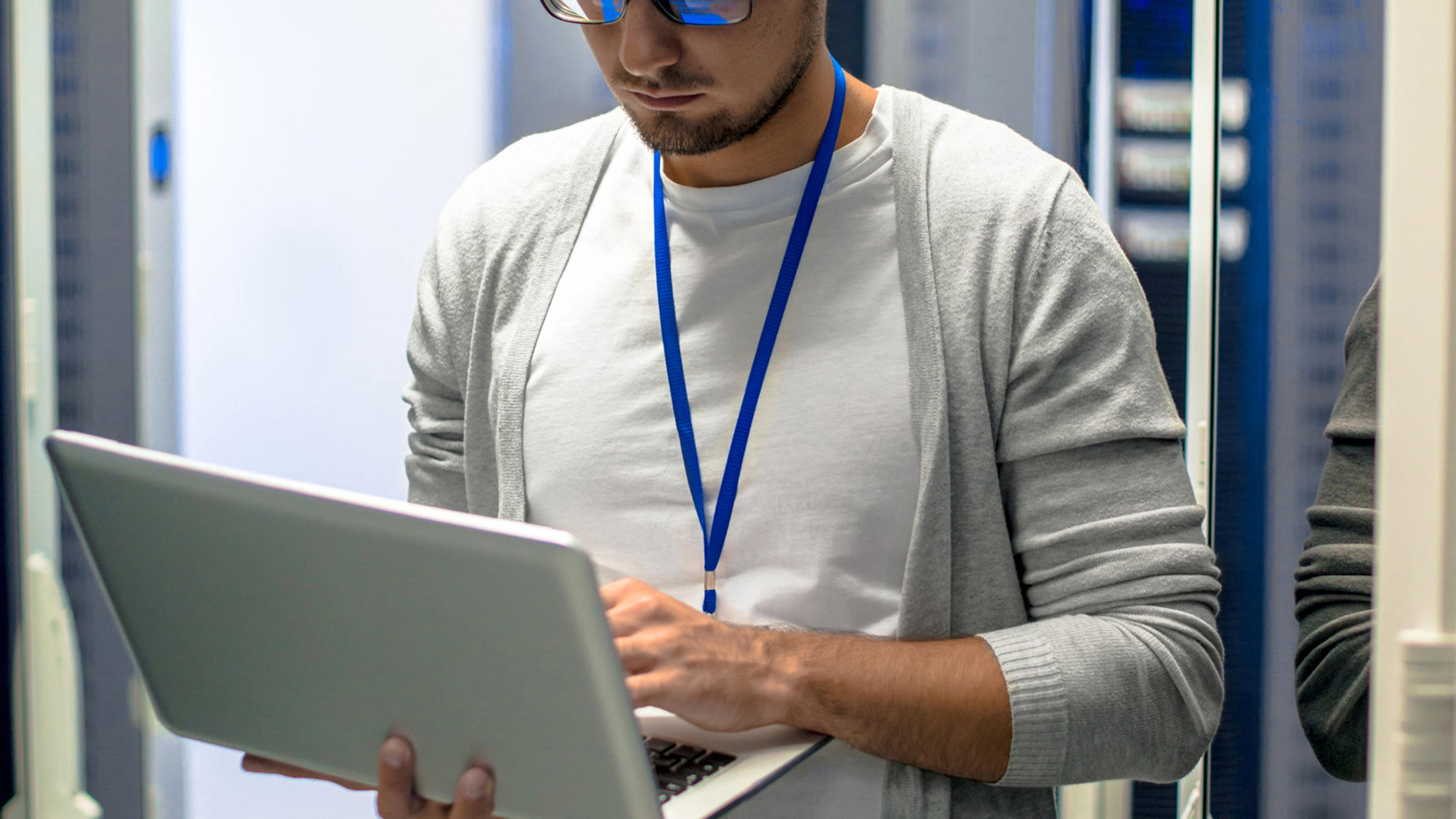 IT professional with a laptop in a server room — Asterisk PBX infrastructure for mobile softphones