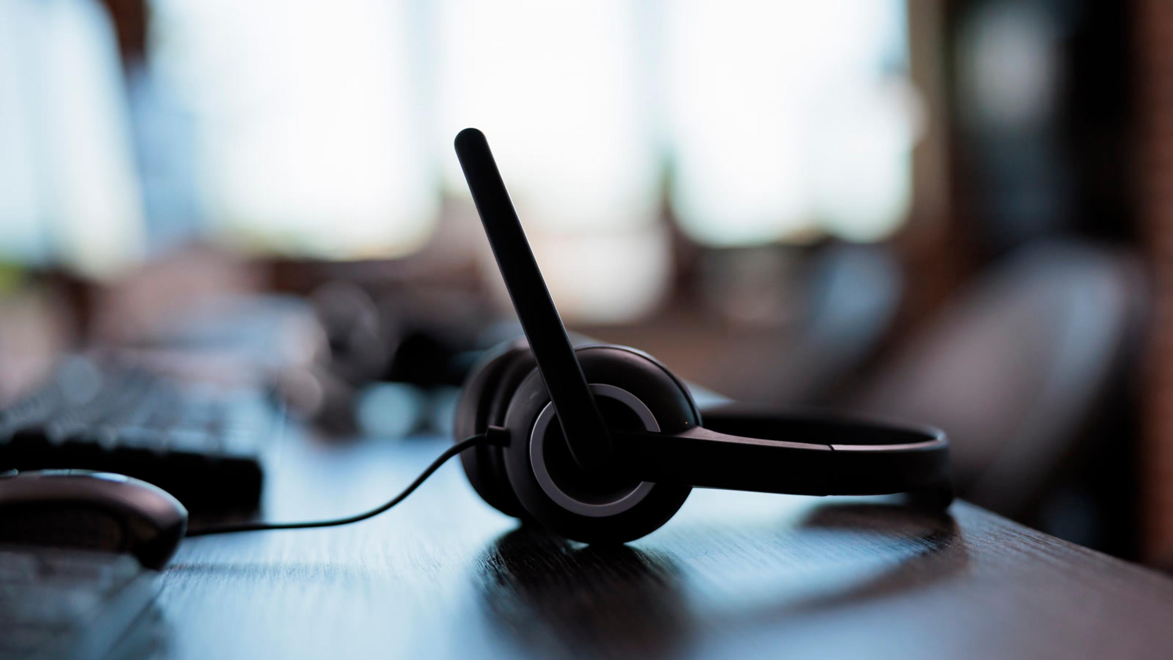 Close-up of a black headset on a desk for FusionPBX softphone provisioning