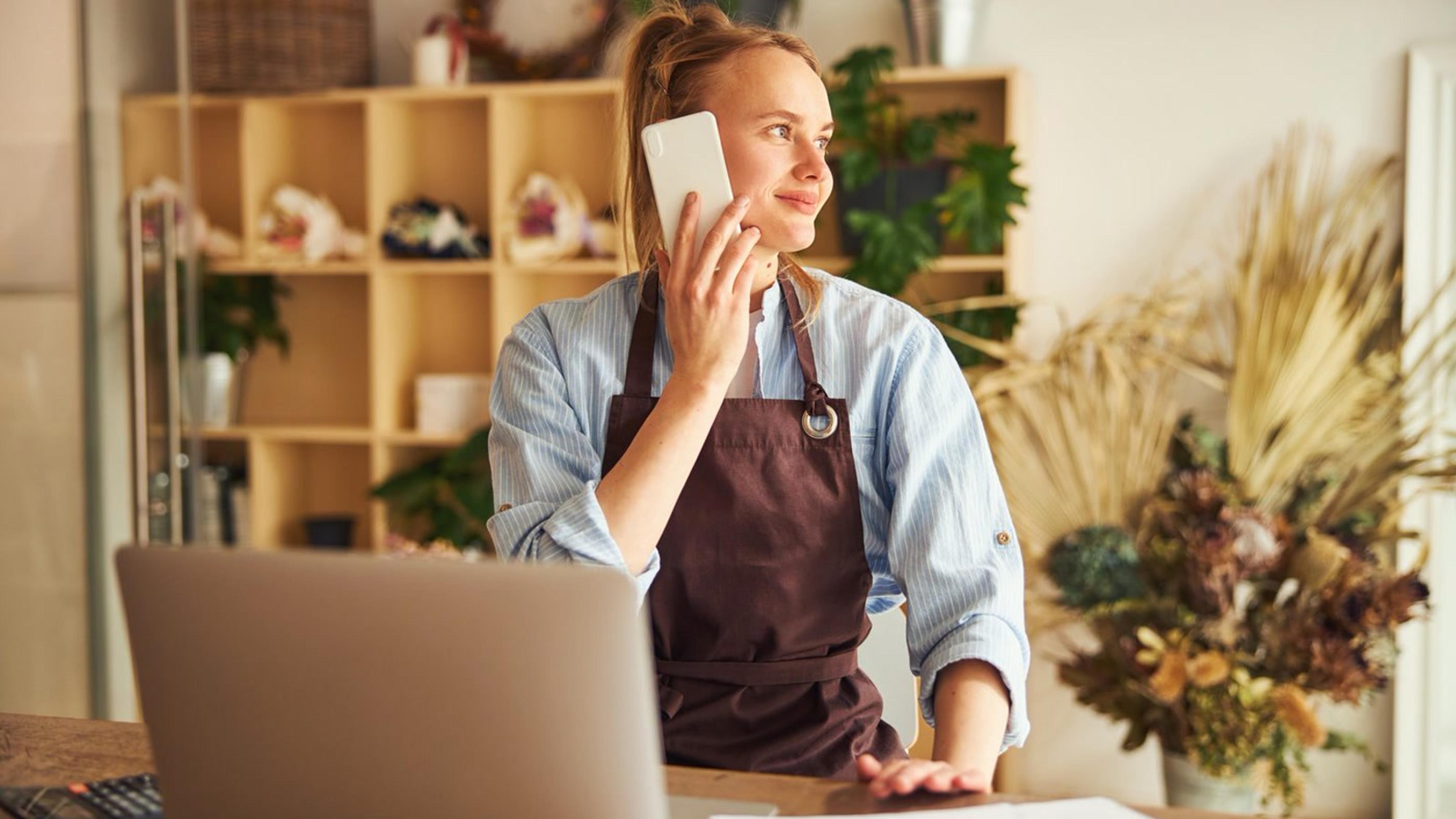 Cheerful woman talking on phone — missed call text-back follow-up