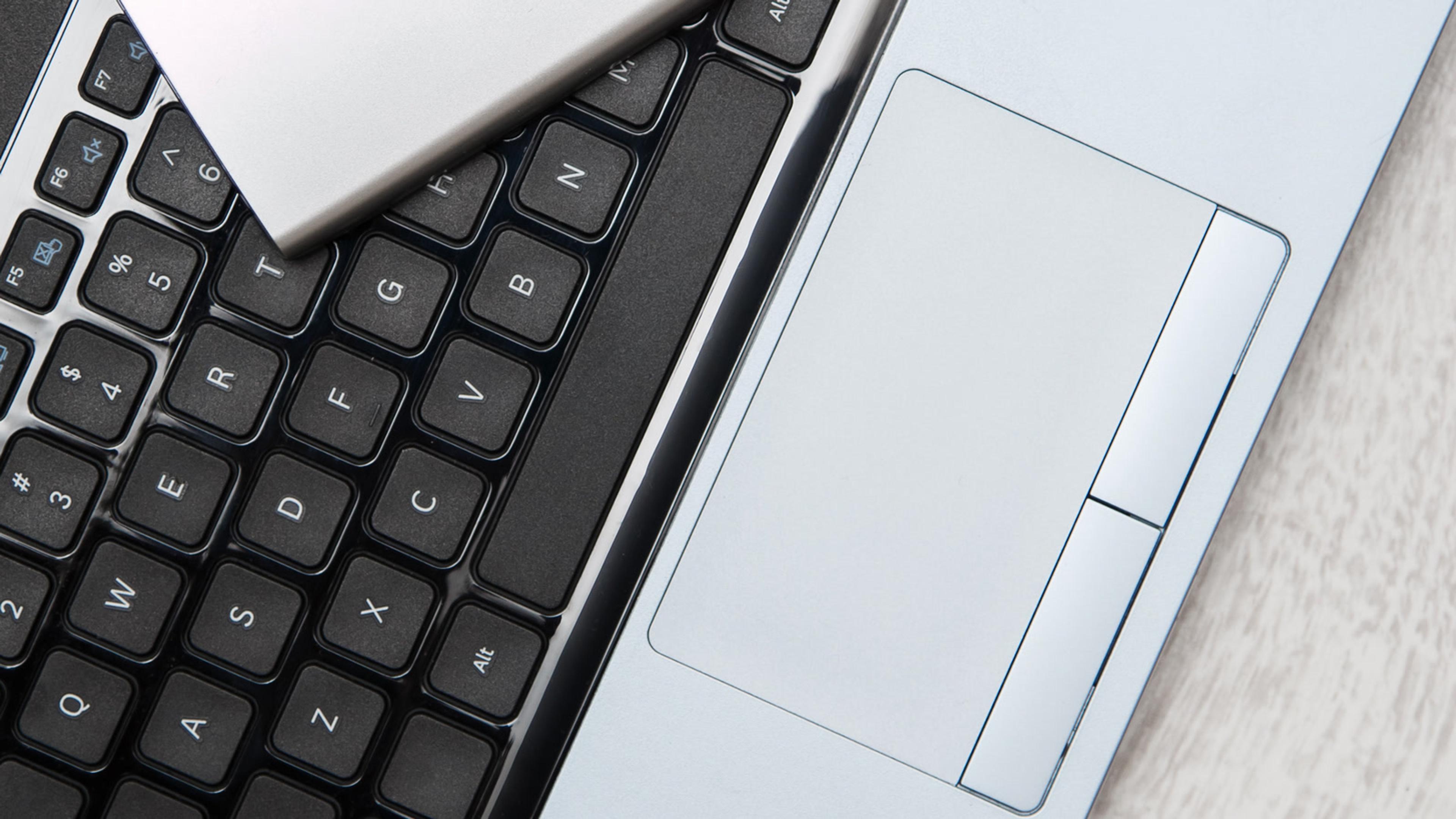 External hard drive resting on a laptop keyboard — secondary media copy for a small-business 3-2-1 backup strategy