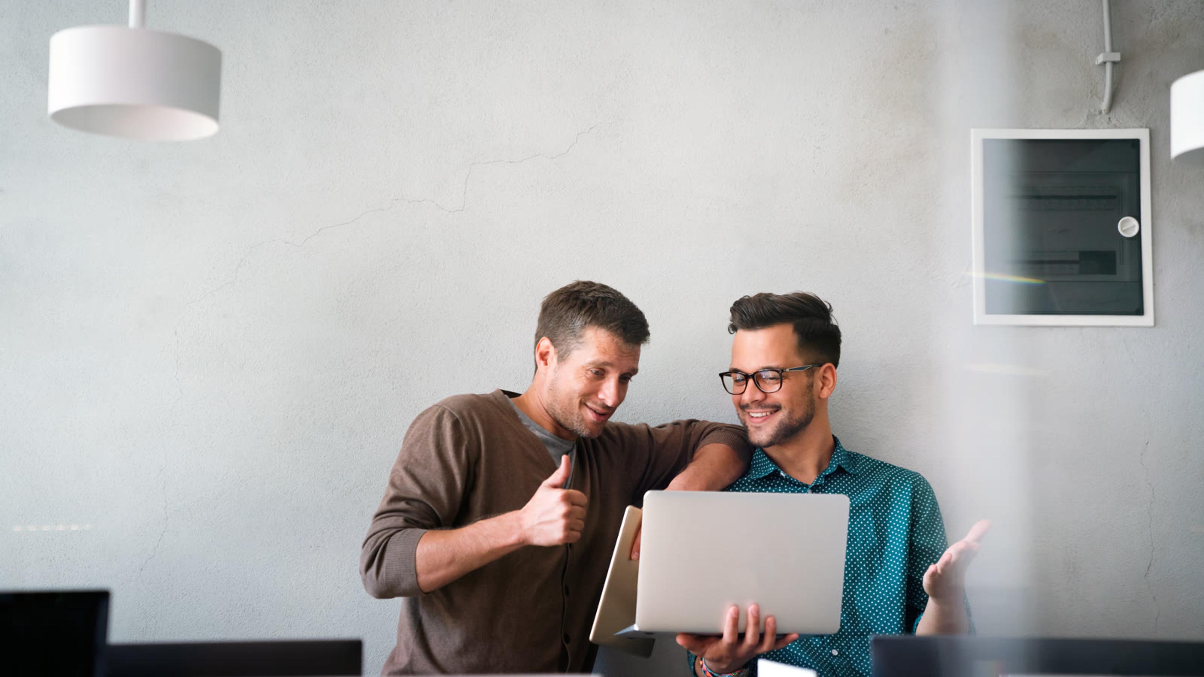 Two colleagues reviewing a laptop together, like an IT provider looking after a small business phone system