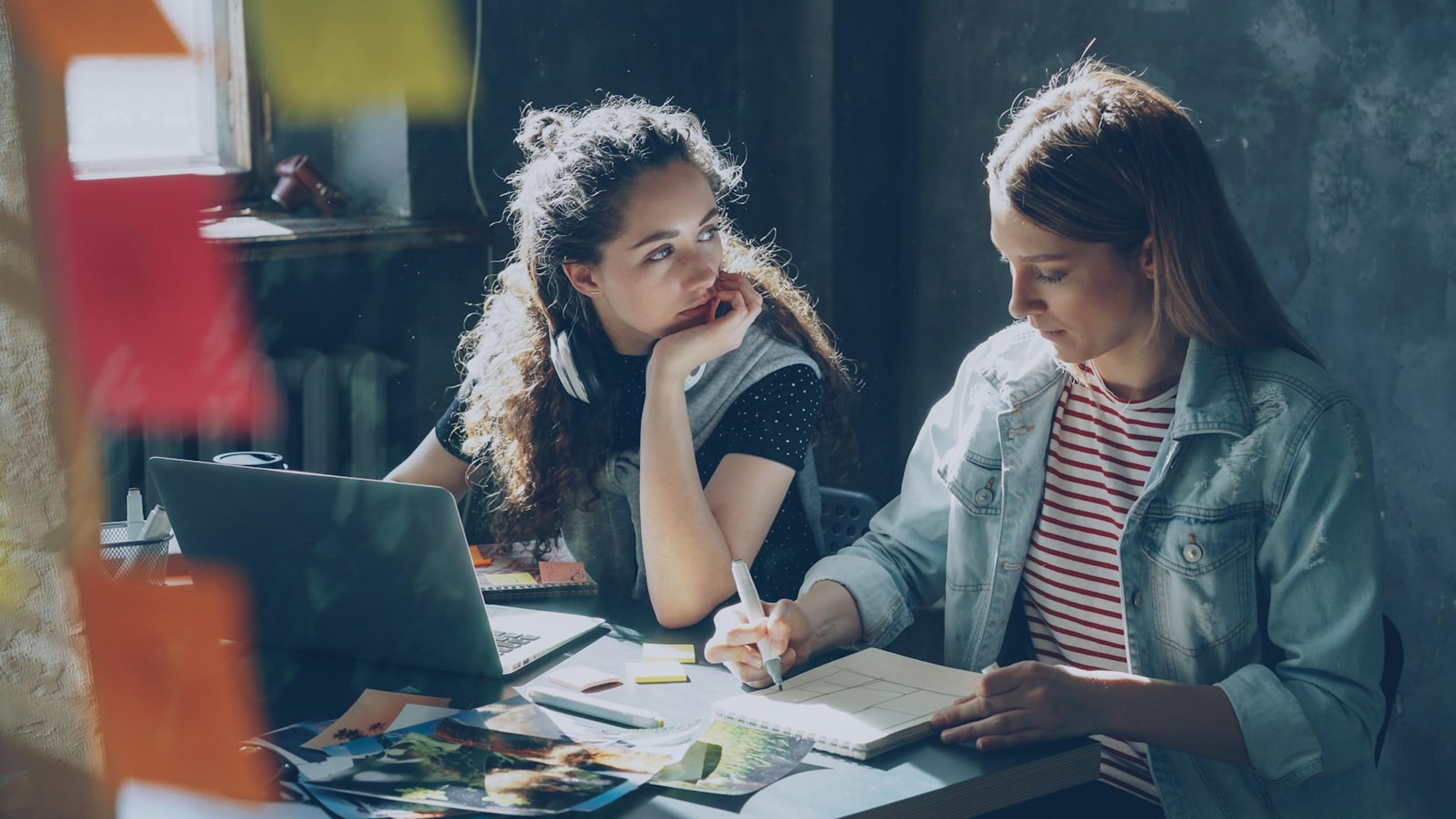 Two colleagues using a computer and headset for business communications