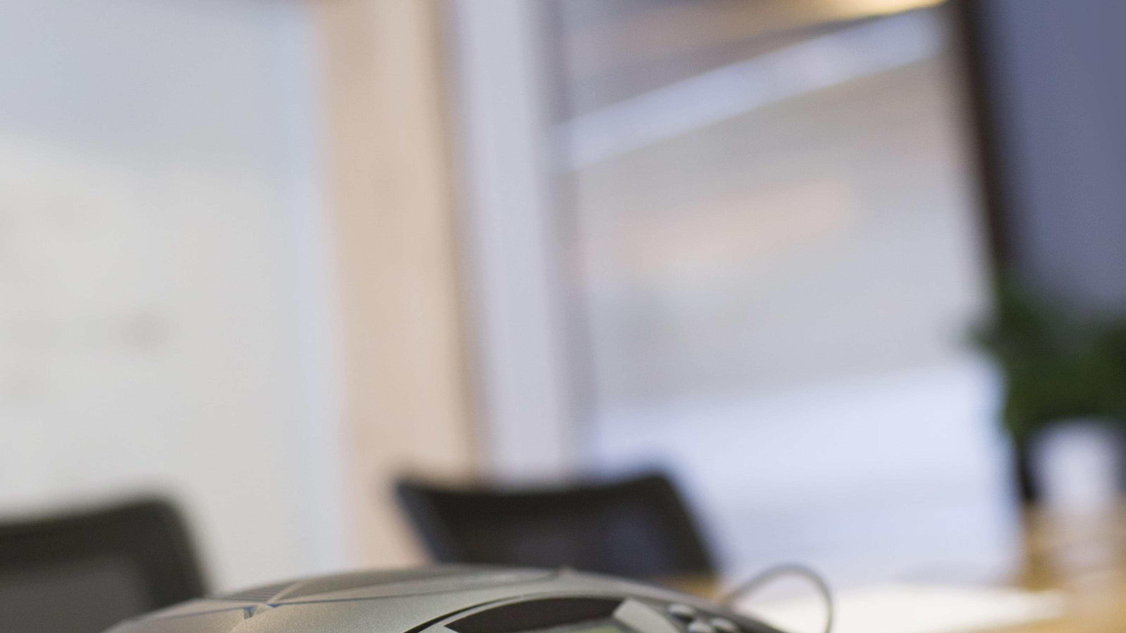 Conference phone on an office meeting table — shared voice tools for helpdesk and contact center teams