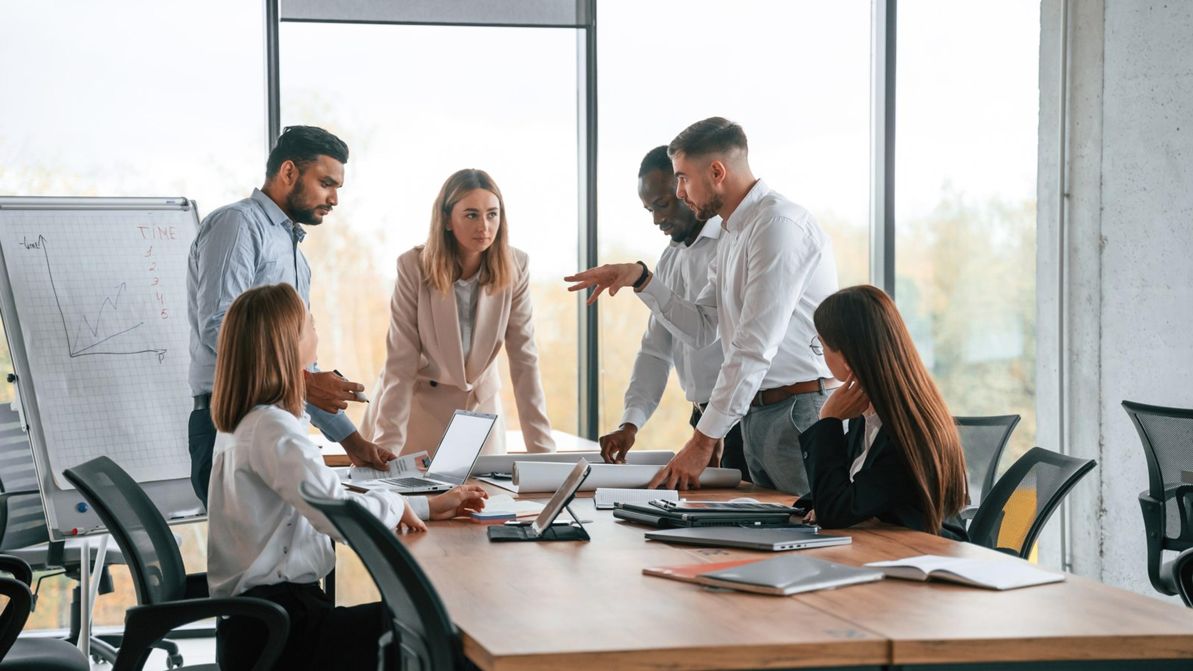 IT and business colleagues collaborating on policy at a meeting table