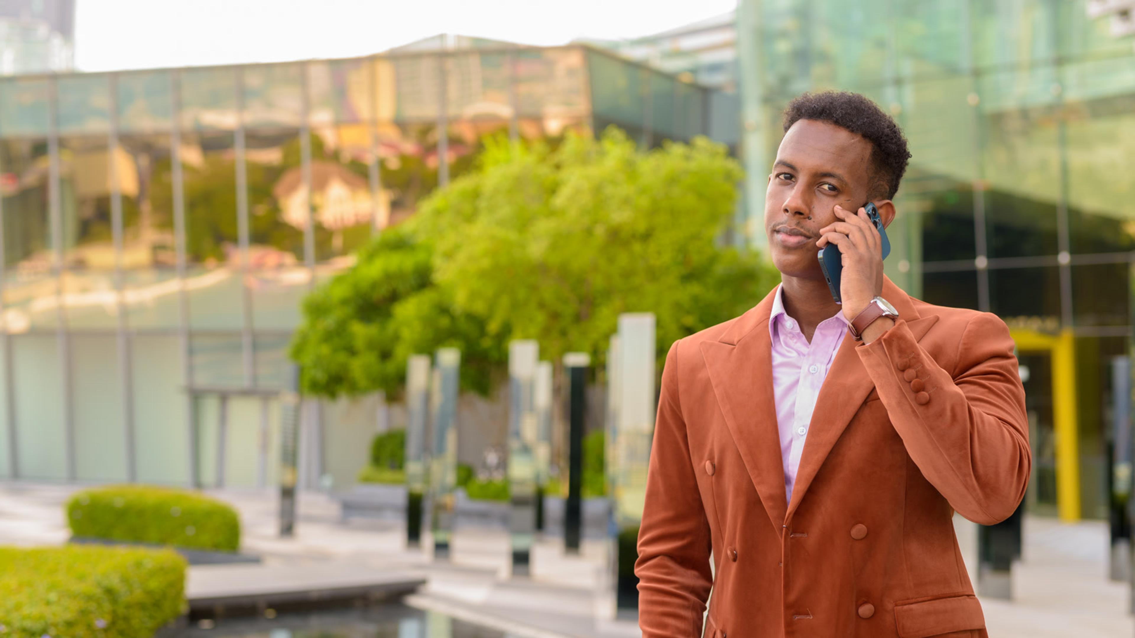 Man in suit speaking on phone in city — Avaya softphone replacement for mobile teams