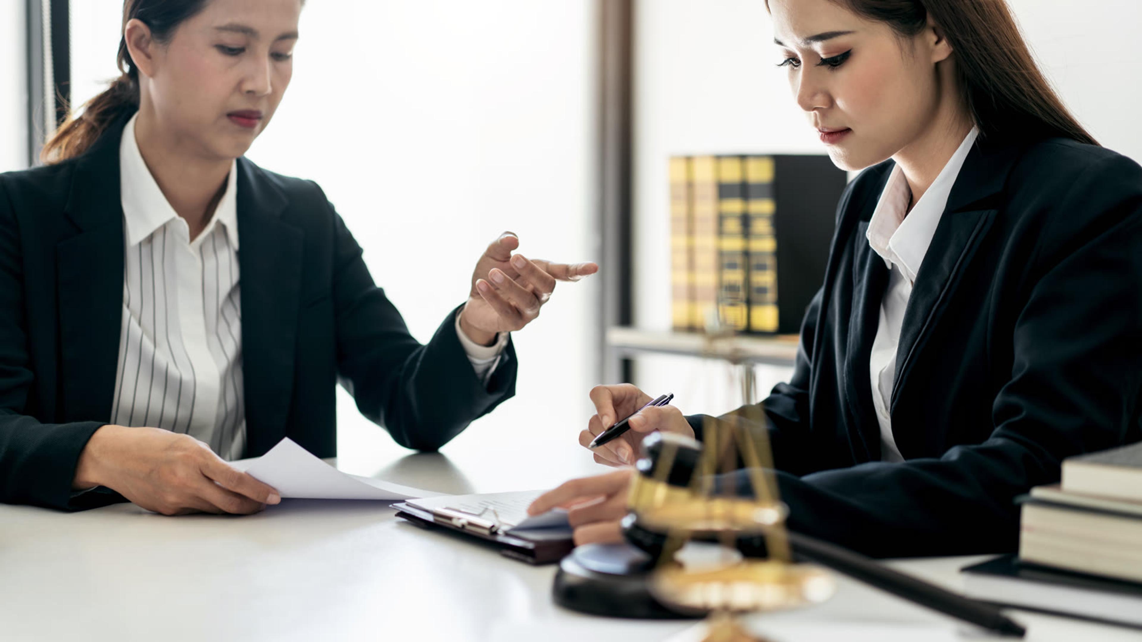 Legal professionals collaborating on client case documents in an office