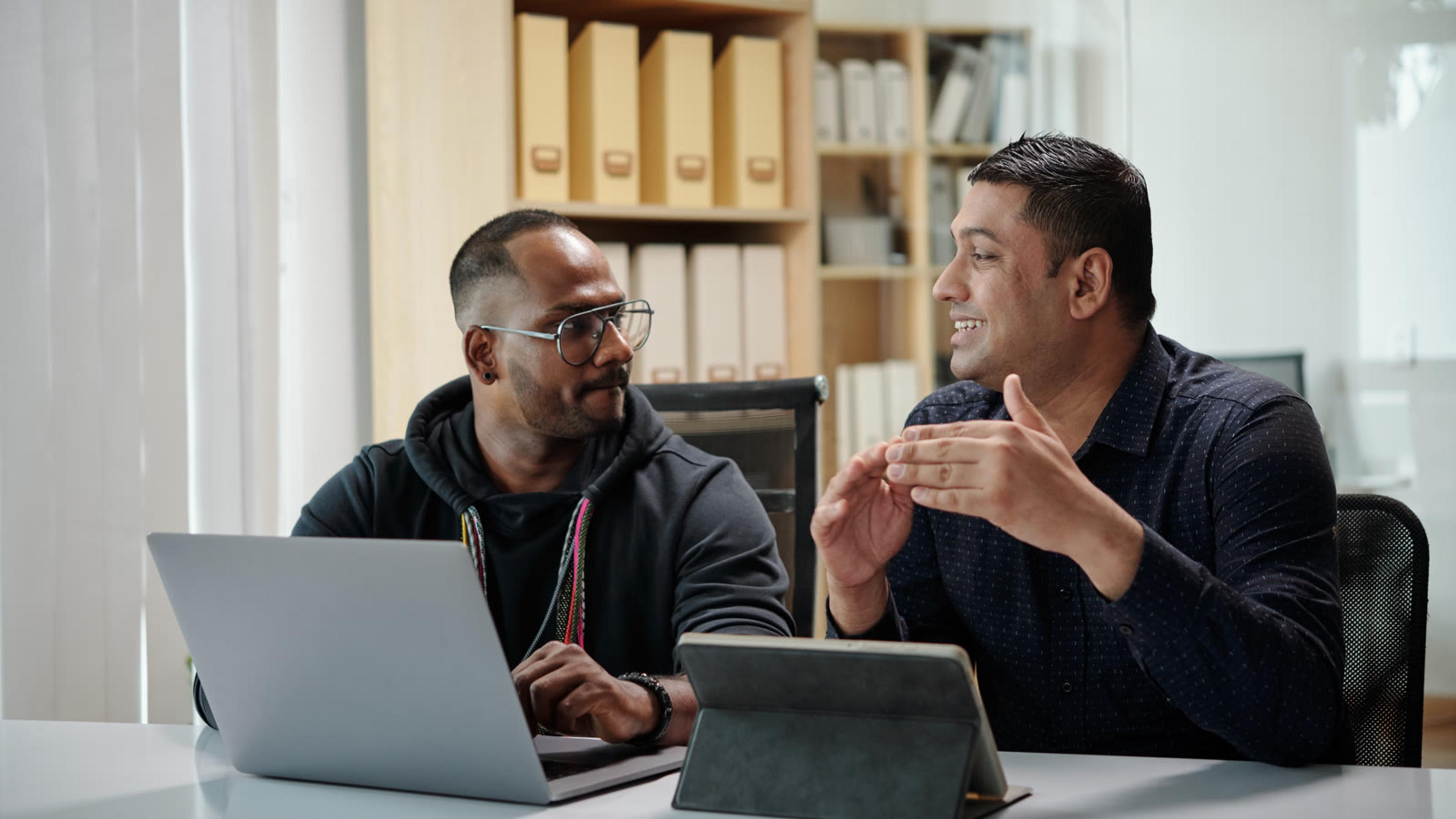 IT consultant meeting a business client at an office desk