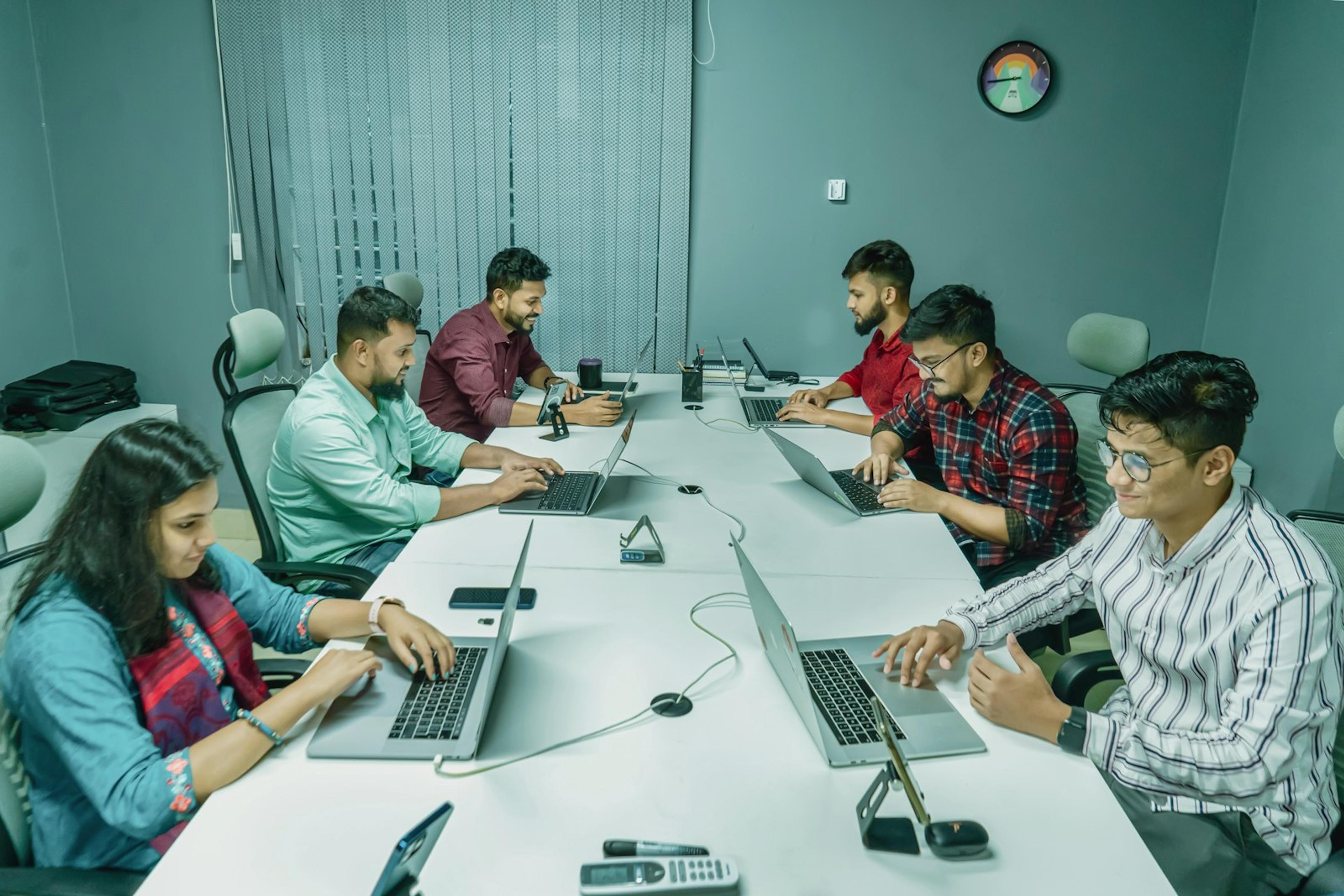 Technology team testing software workflows together on laptops