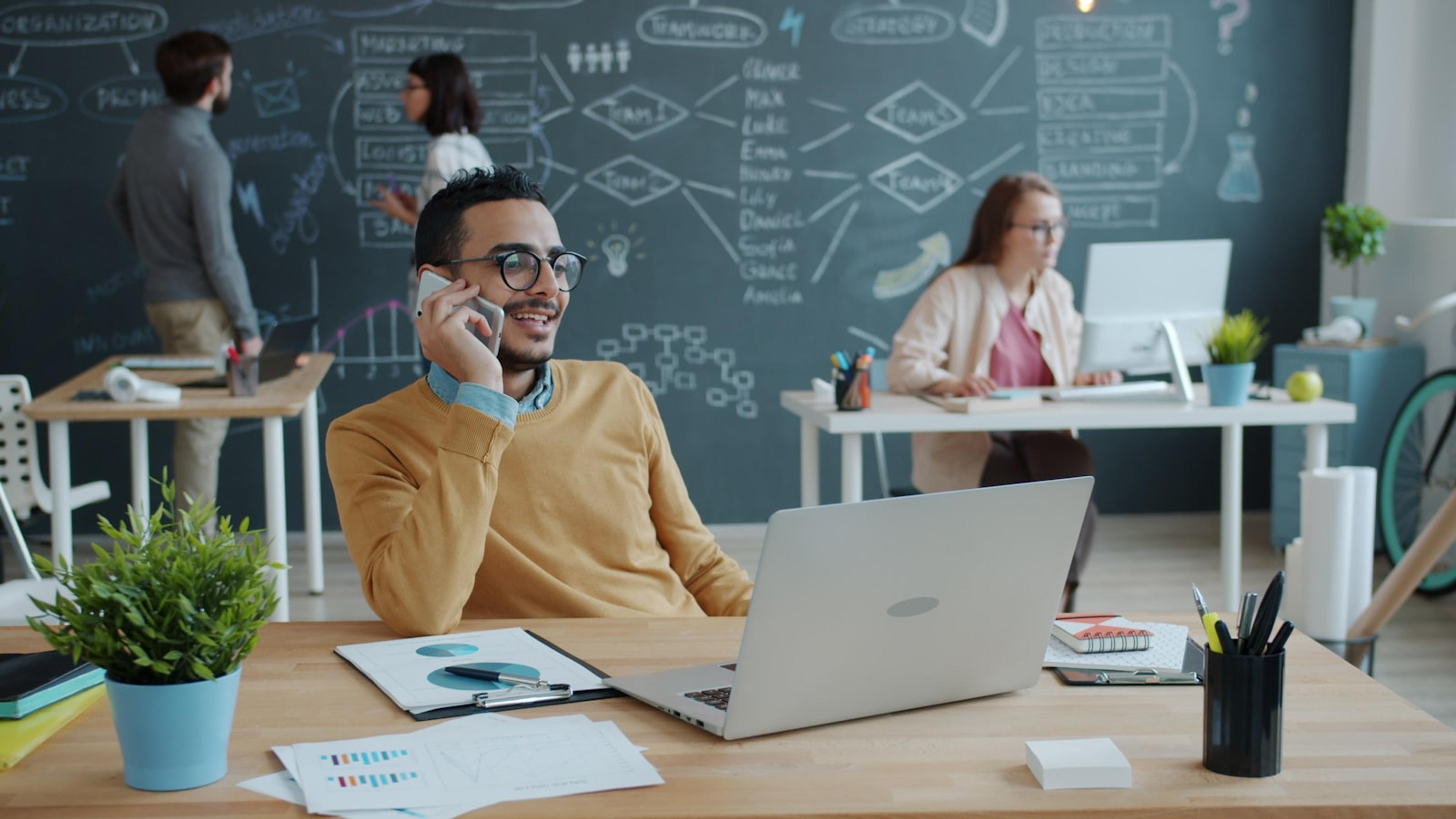 Business professional making a customer phone call in an office