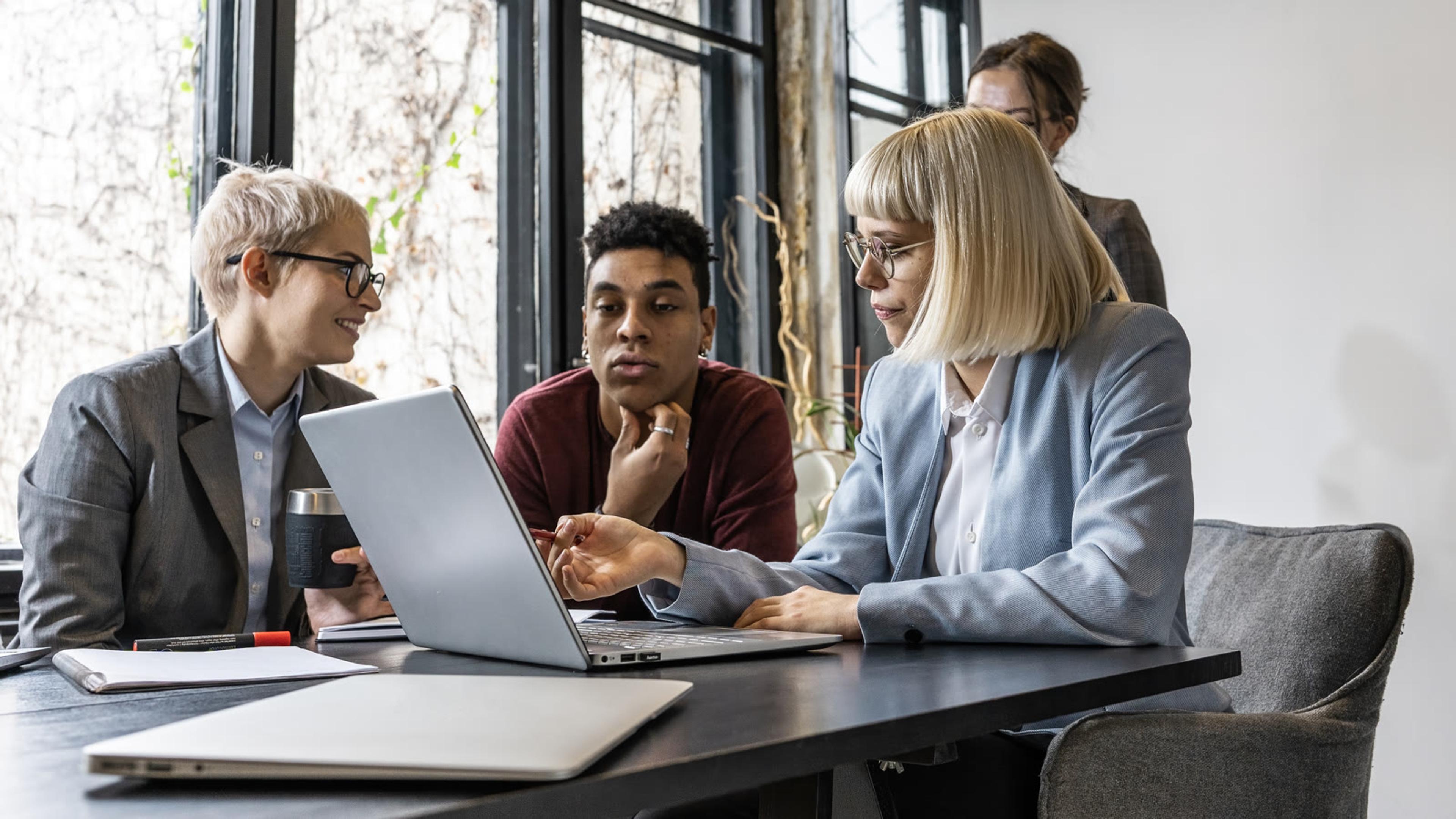 Professionals collaborating around a meeting table planning multi-site call routing