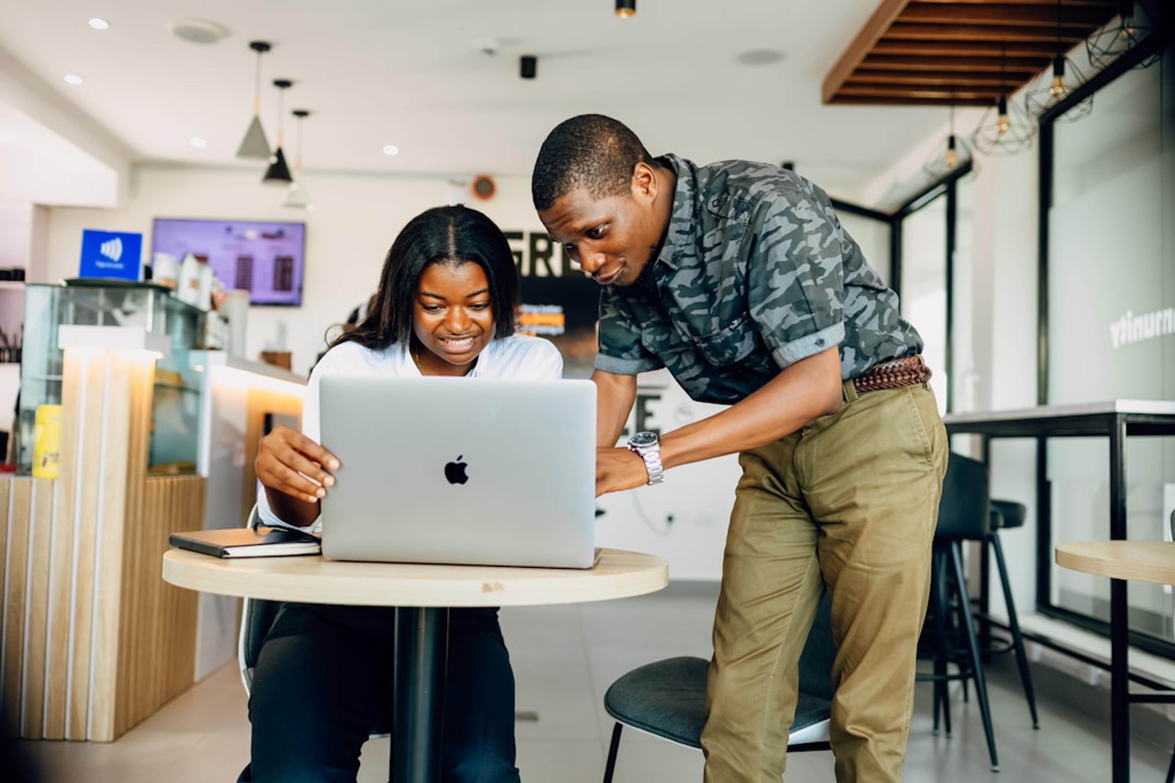Two business professionals collaborating while looking at a laptop together