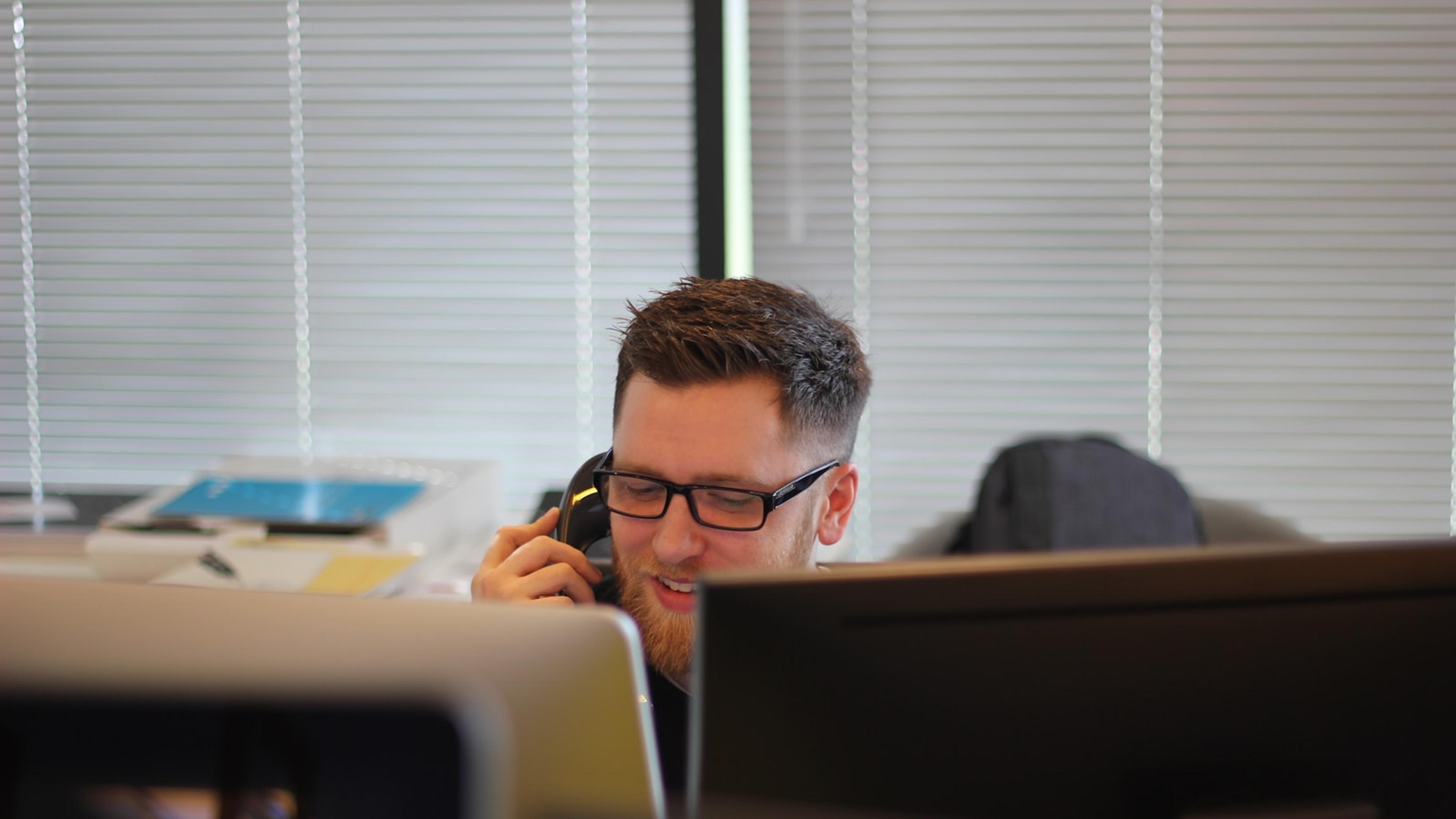 Employee testing an IP desk phone during a business phone system pilot