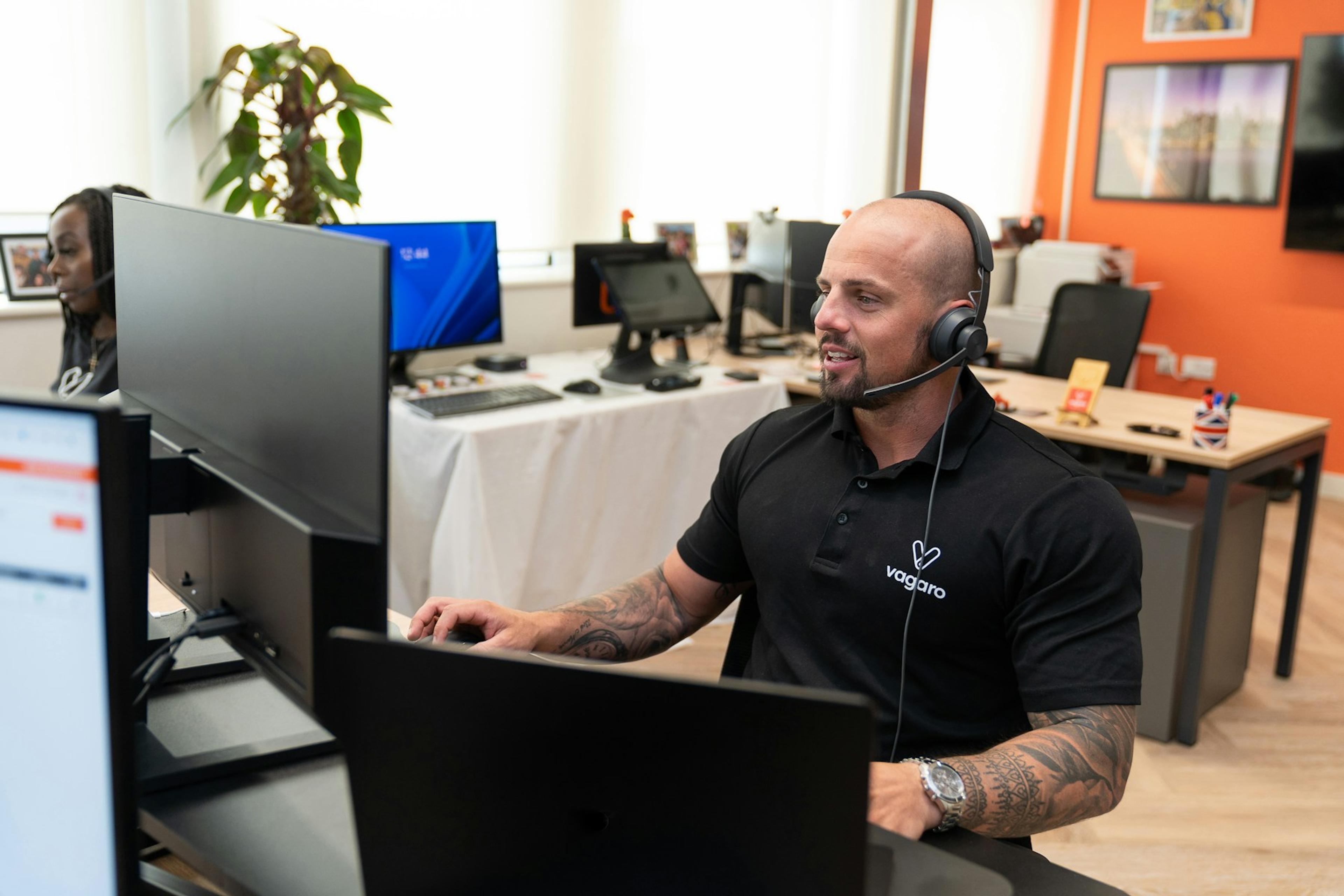 Customer support agent wearing a headset while working at a computer