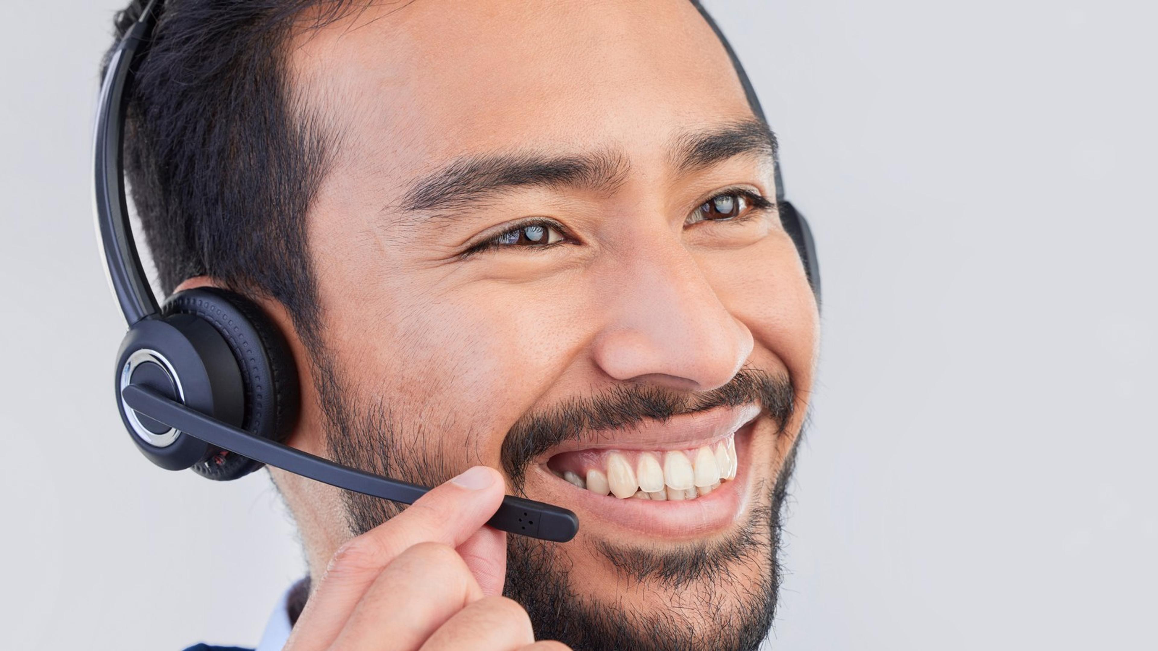 Smiling agent wearing a headset in a corporate setting — quality assurance review for contact center calls