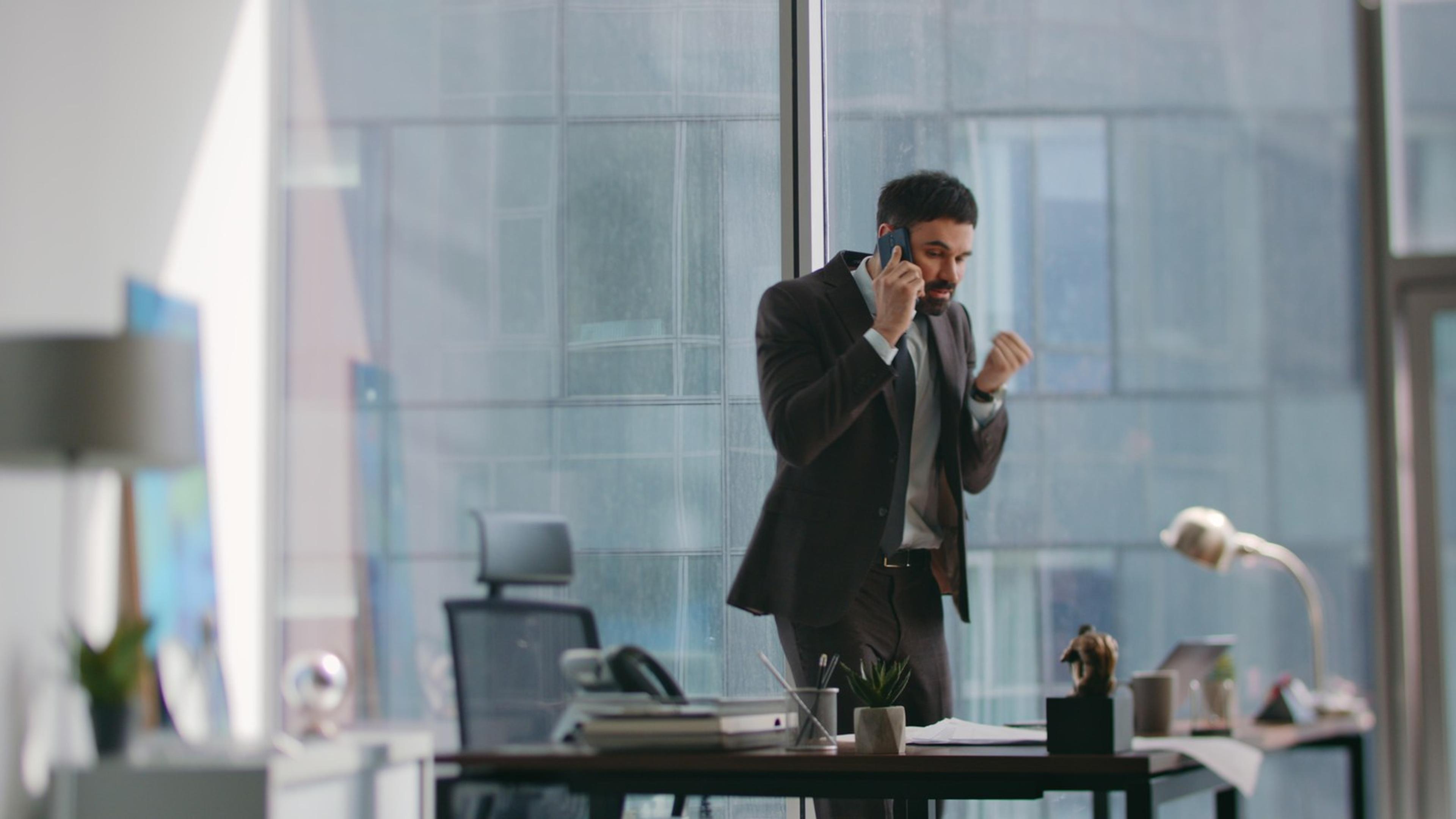 Professional man talking on a phone in the office — mobile SIP softphone calling
