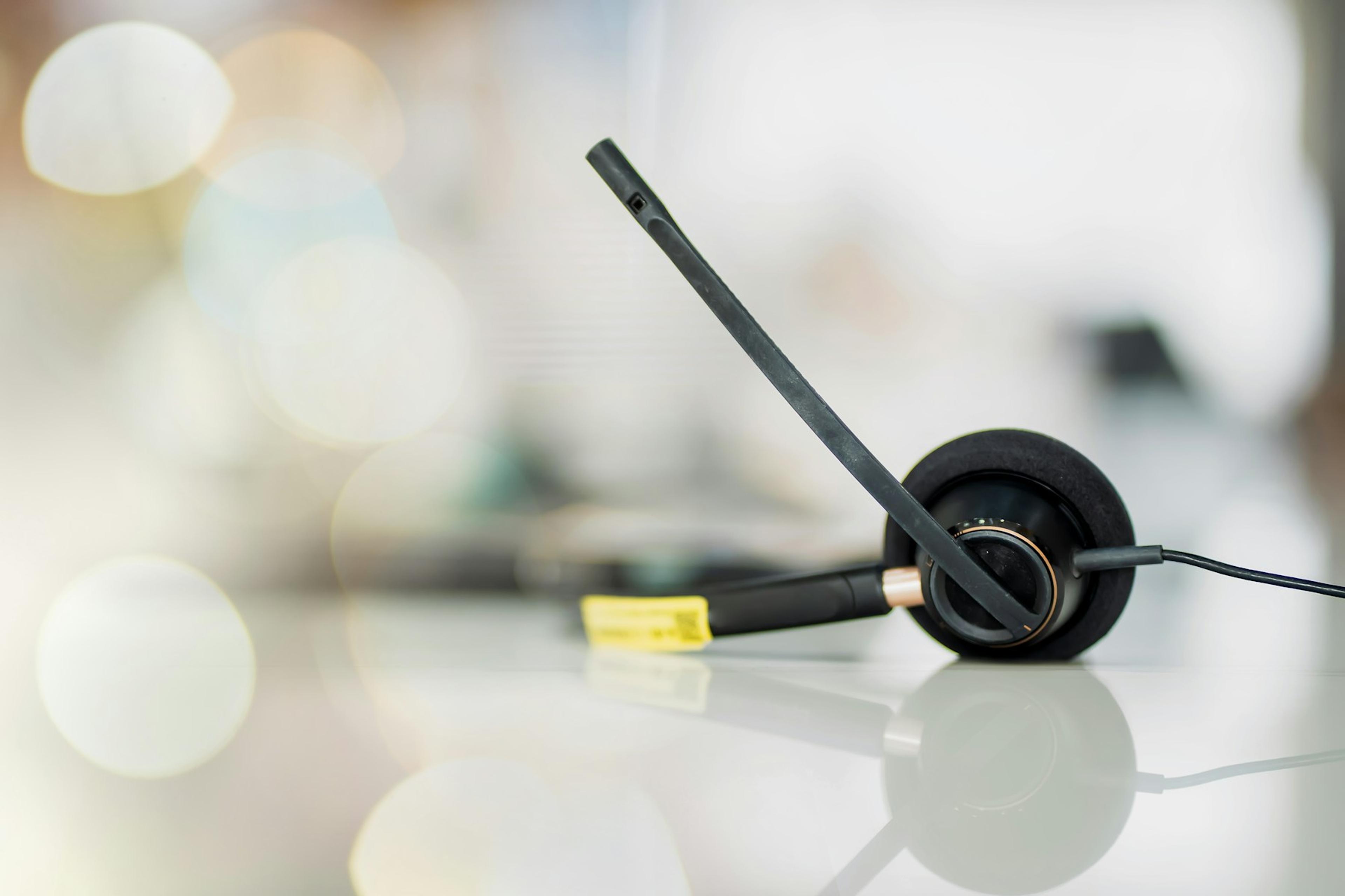 Business headset beside a computer keyboard ready for customer calls