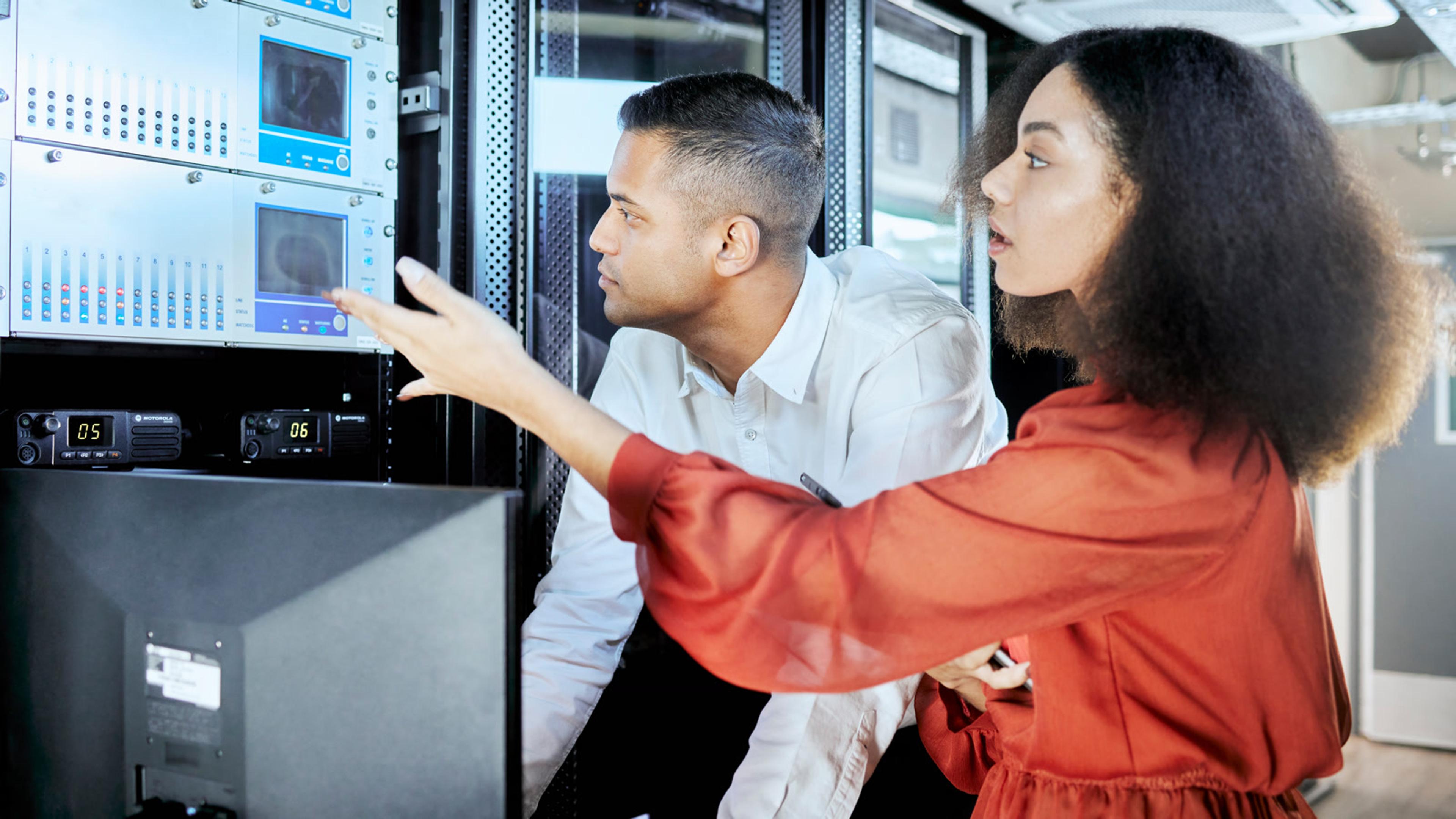 IT professionals reviewing systems in a server room during cloud PBX migration