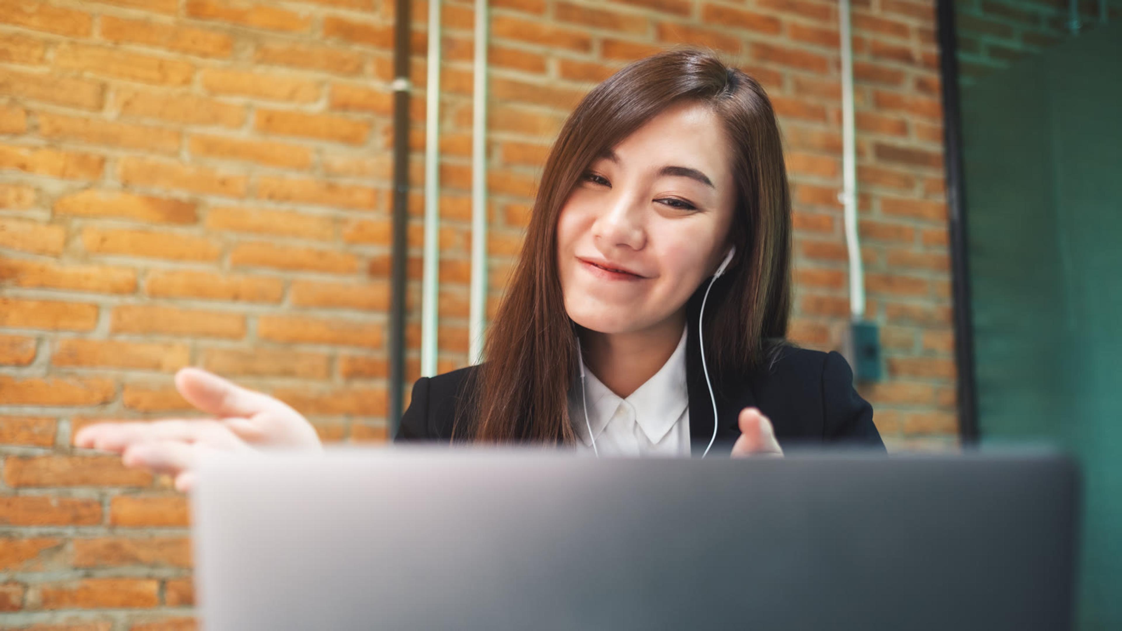 Business professional on a headset call with a laptop in an urban office