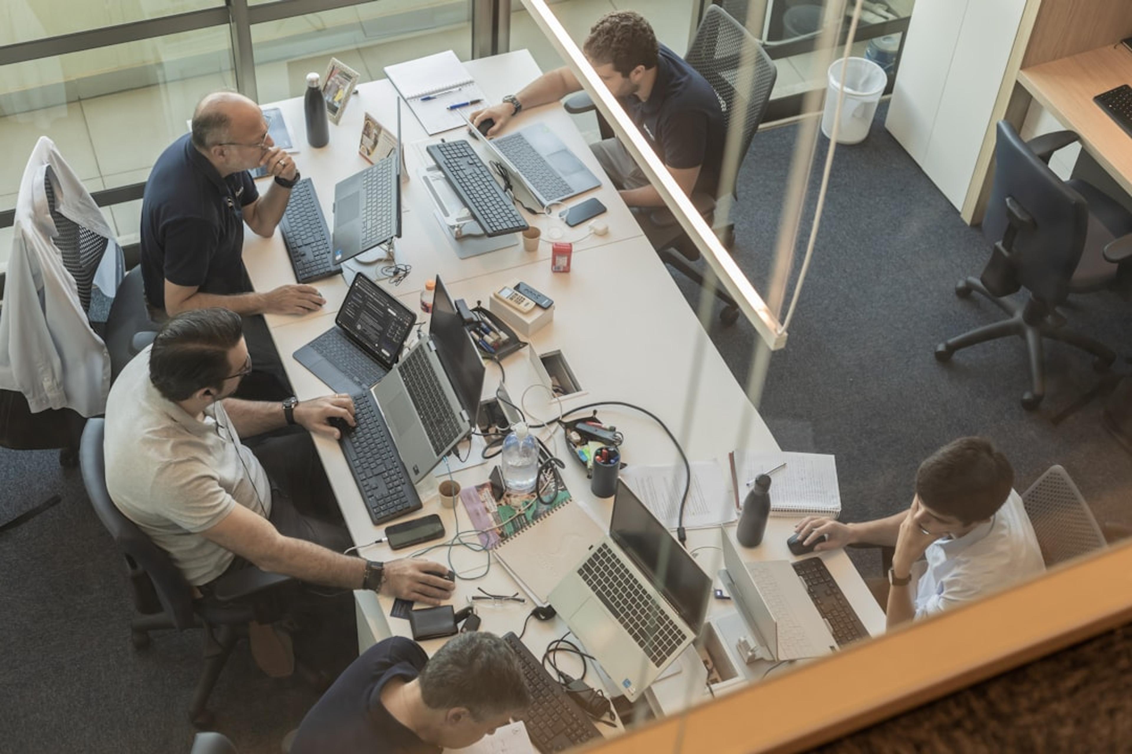 Team working at desks in a modern office environment with multiple workstations
