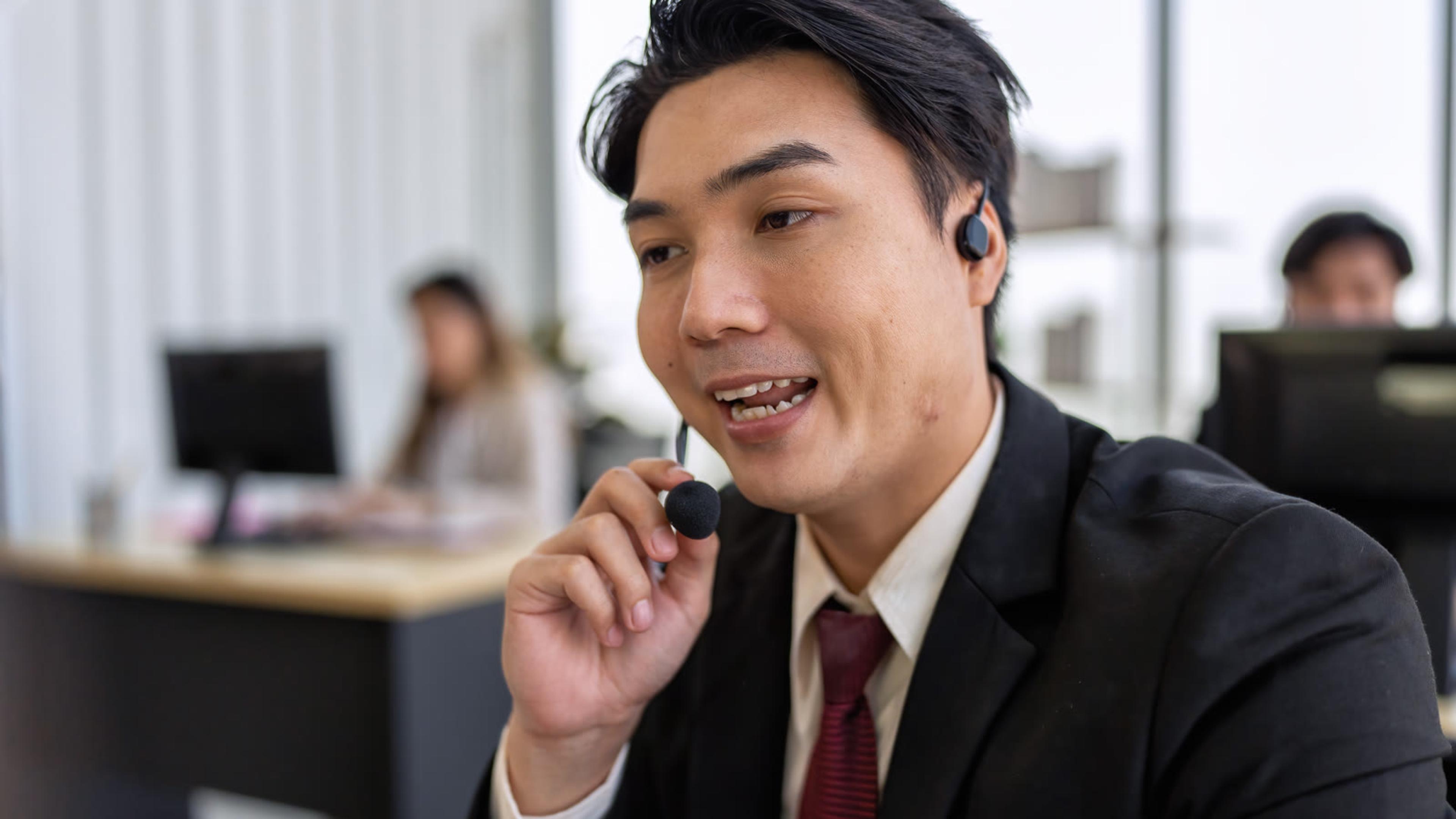 Office professional wearing a headset on a business call