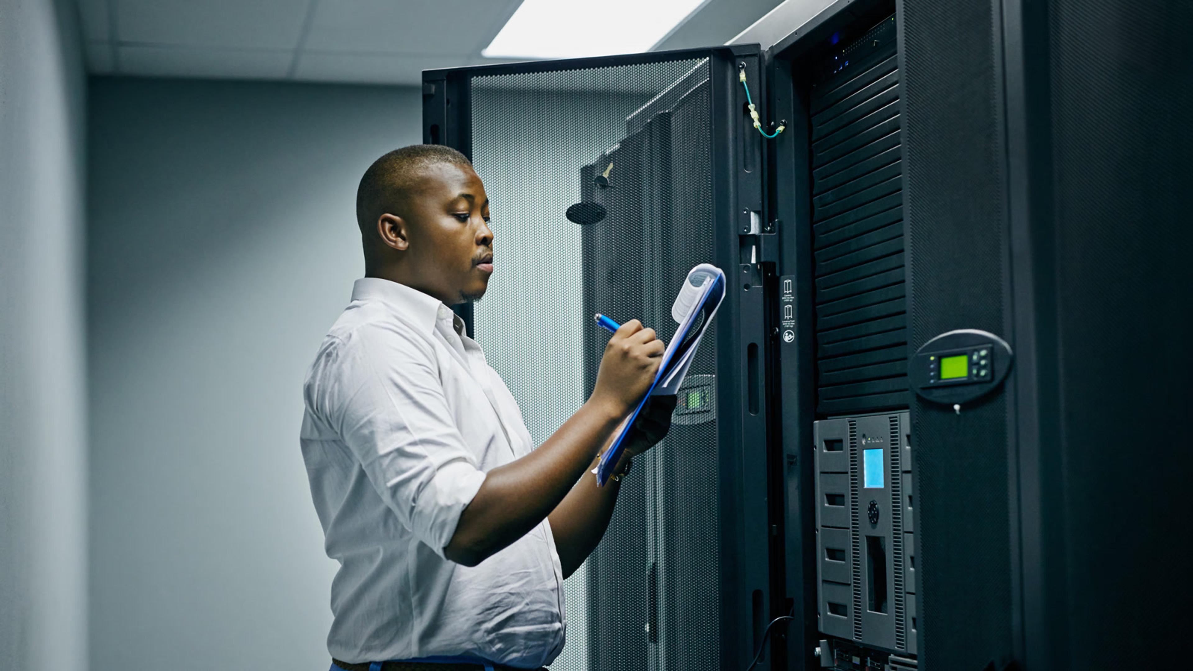 Engineer inspecting server equipment in a data center