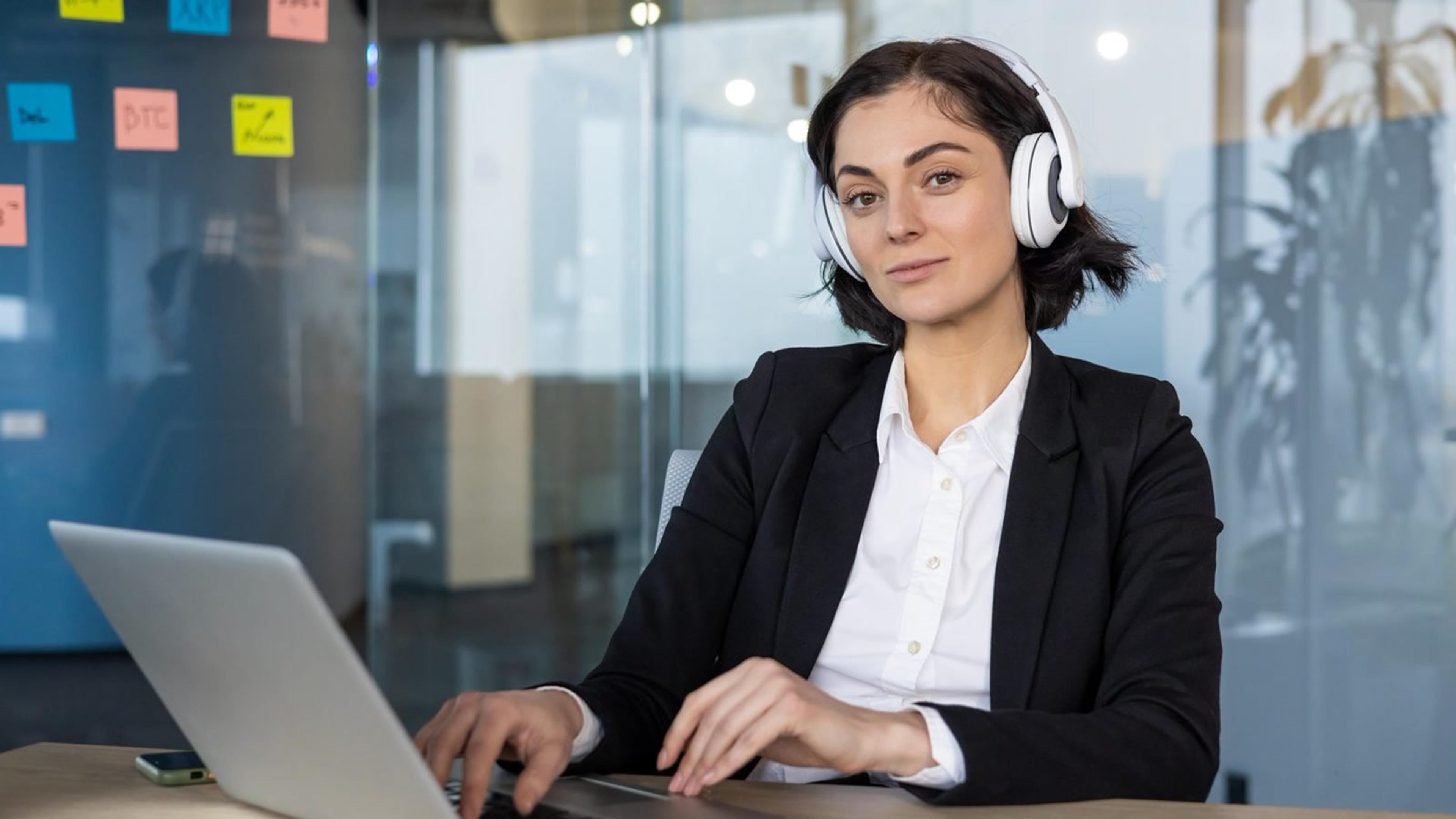 Woman working on a laptop in a bright modern office — desktop click-to-call