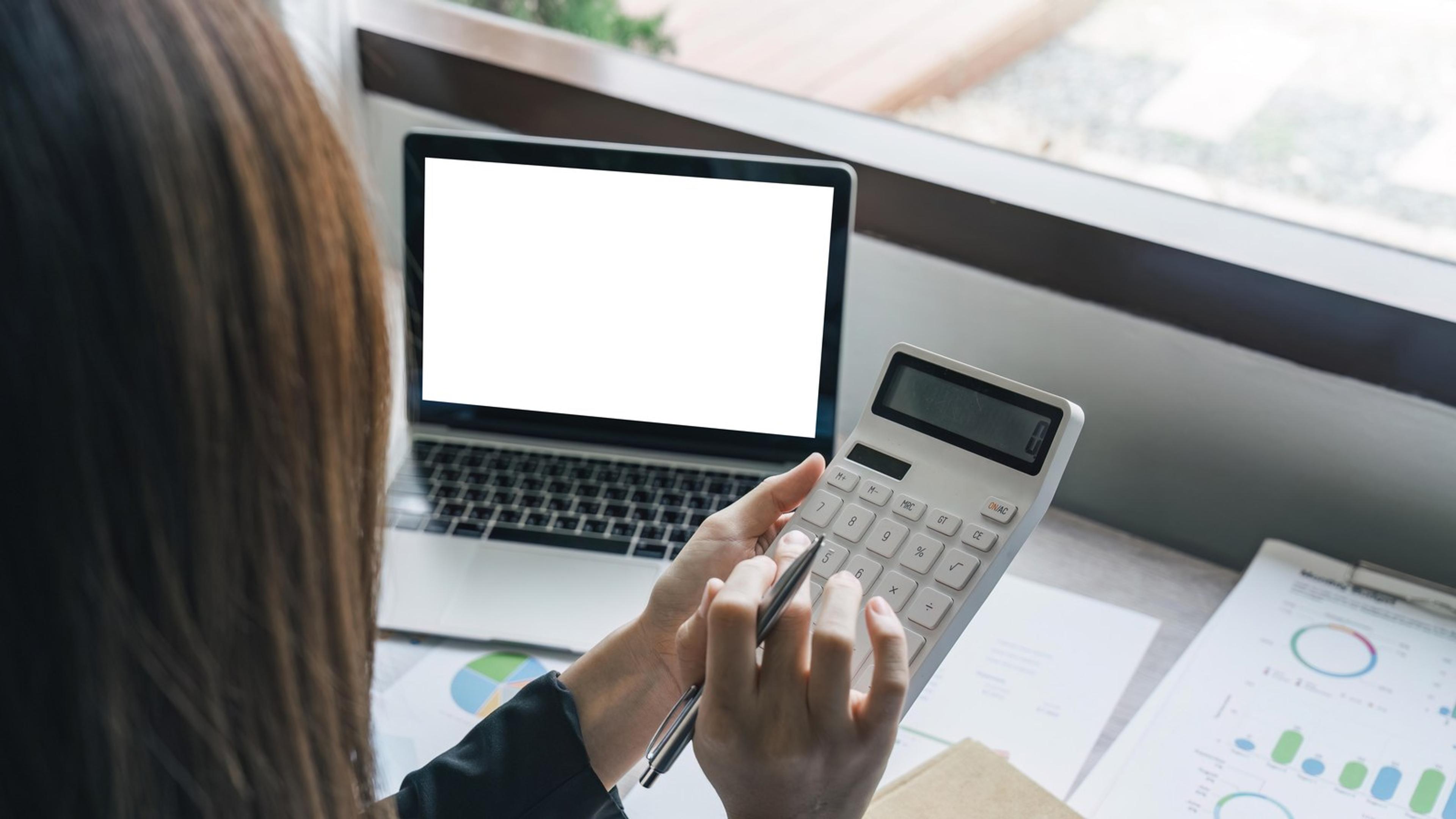 Professional reviewing numbers at a laptop — SaaS spend and shadow IT discovery