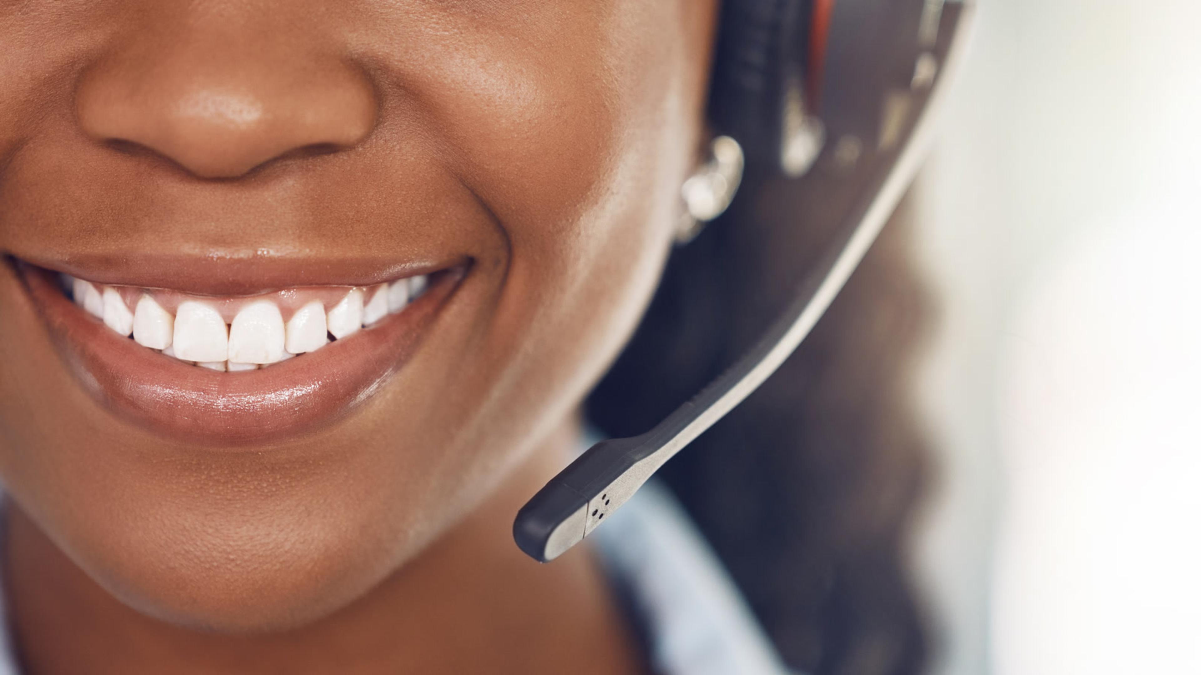 Close-up of a woman smiling while wearing a headset — softphone headset lifestyle for Asterisk mobile calling