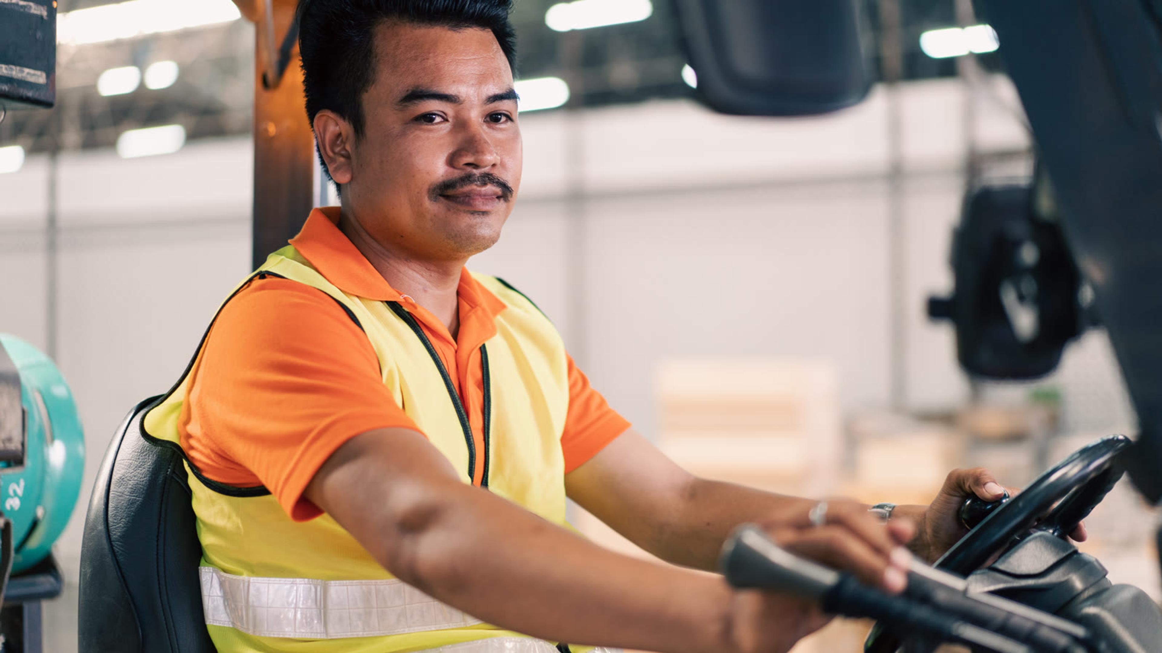 Warehouse operator driving a forklift in a logistics facility