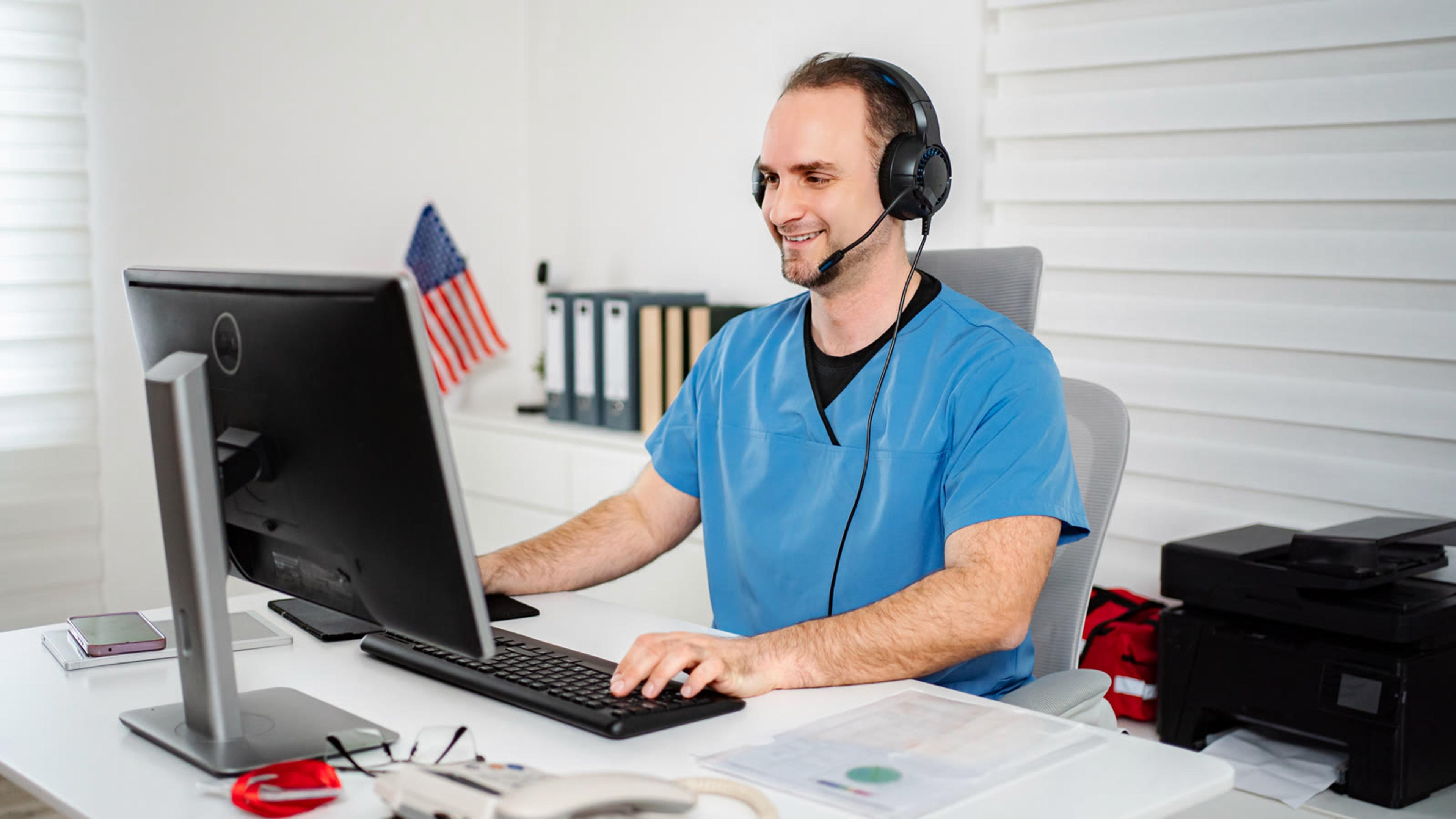 Smiling support technician wearing a headset at his desk
