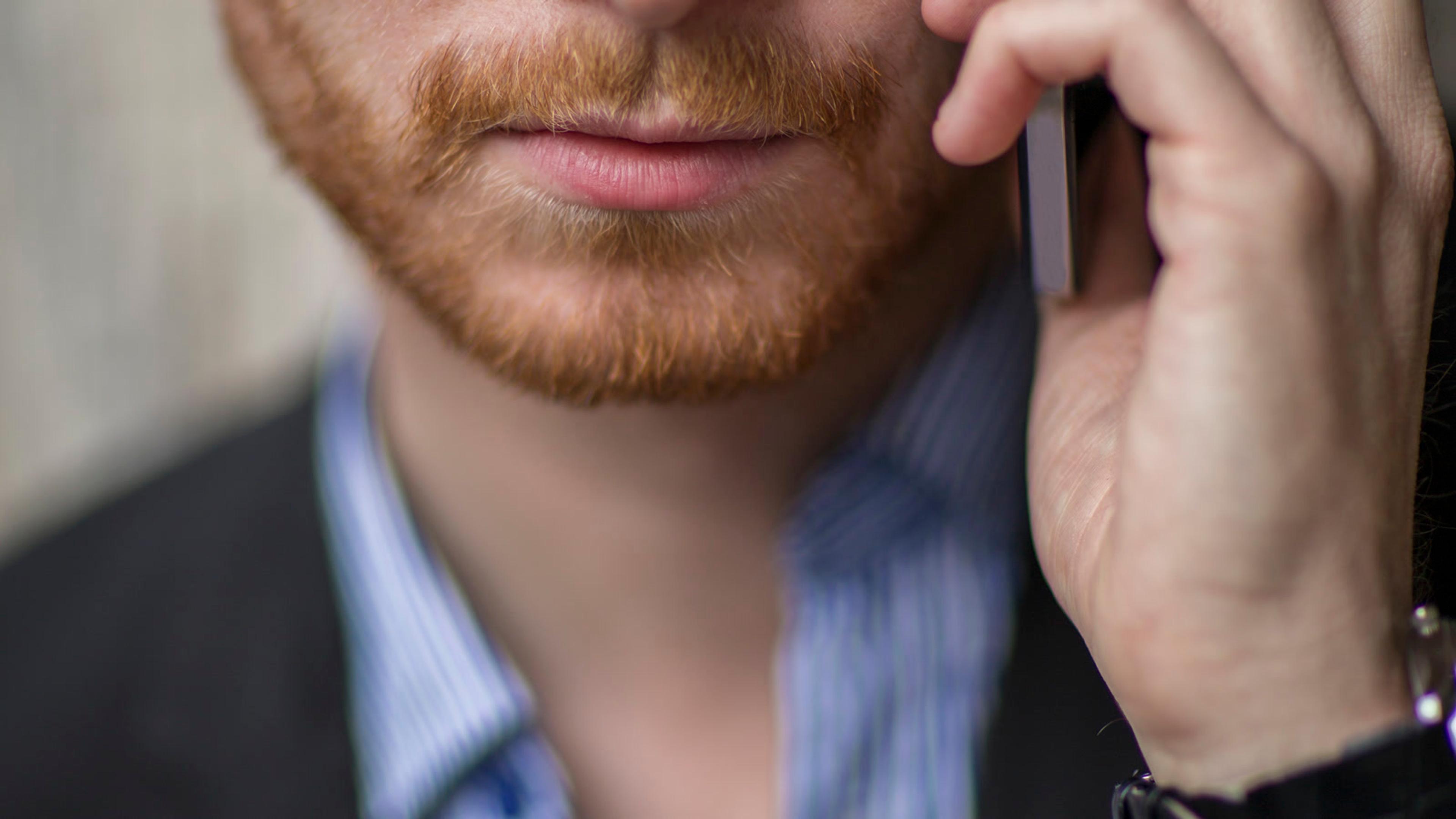 Focused man in a business suit talking on a phone — mobile SIP softphone use
