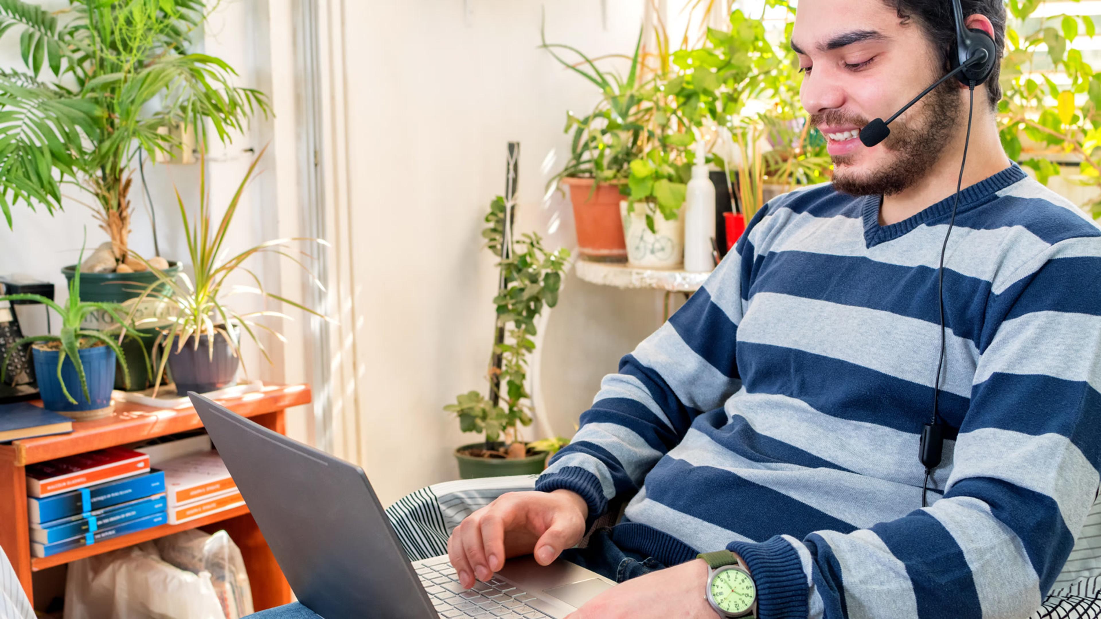 Man working remotely with a laptop at home — securing SIP softphones for remote users