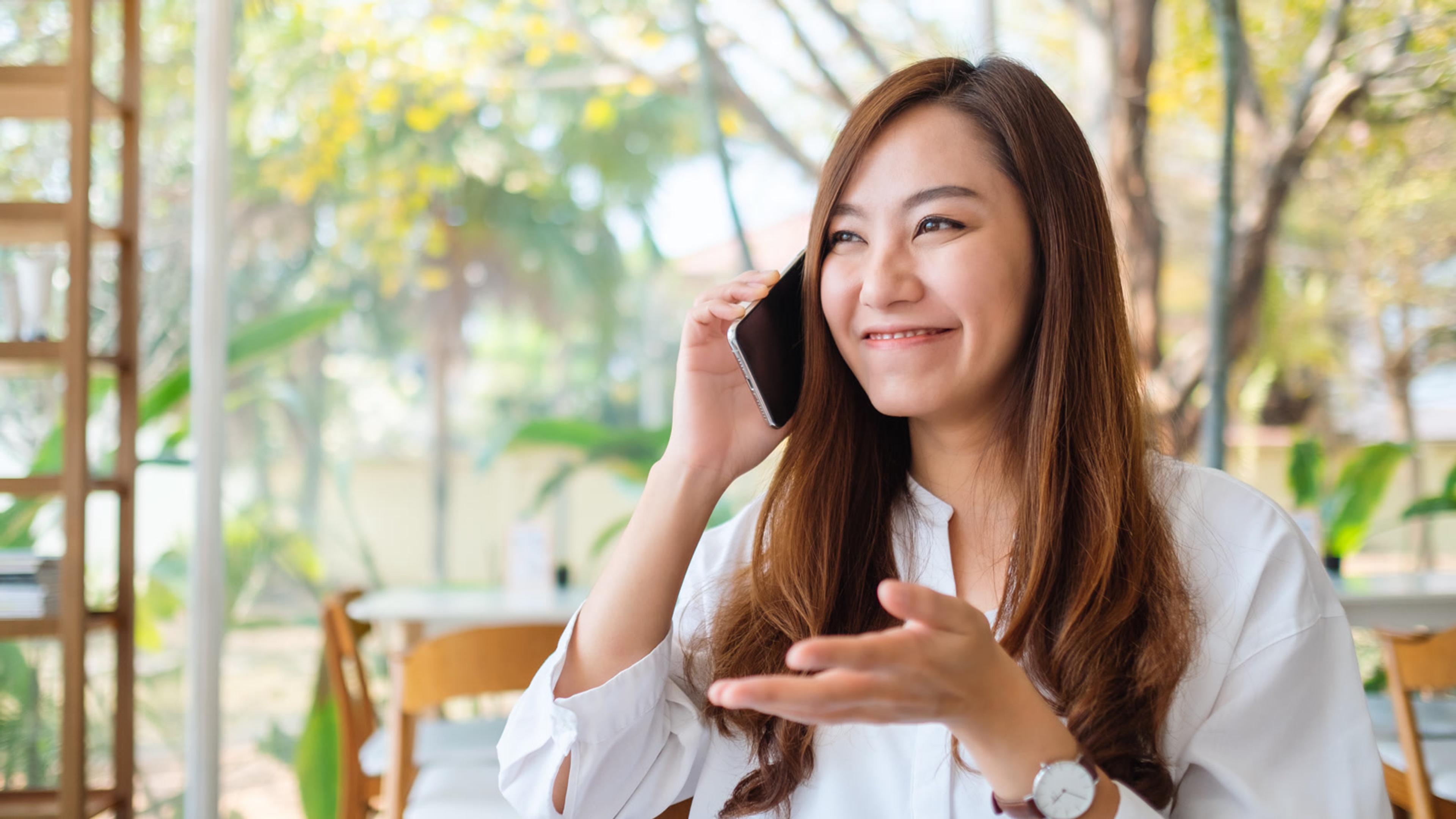 Real estate agent smiling on a smartphone call in a bright modern office lifestyle setting