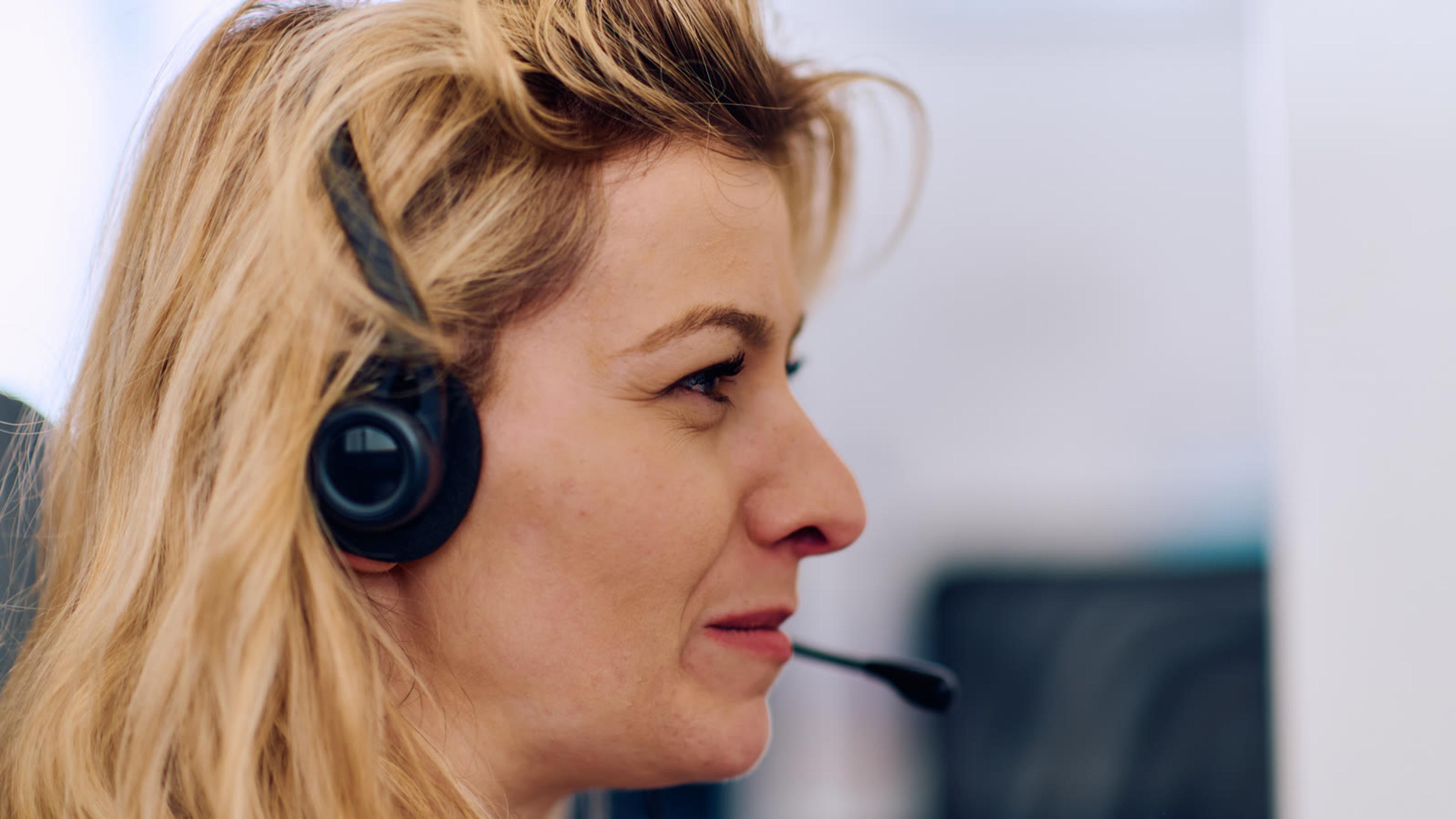 Professional woman with a headset in an office — headset and mic checks for choppy VoIP calls