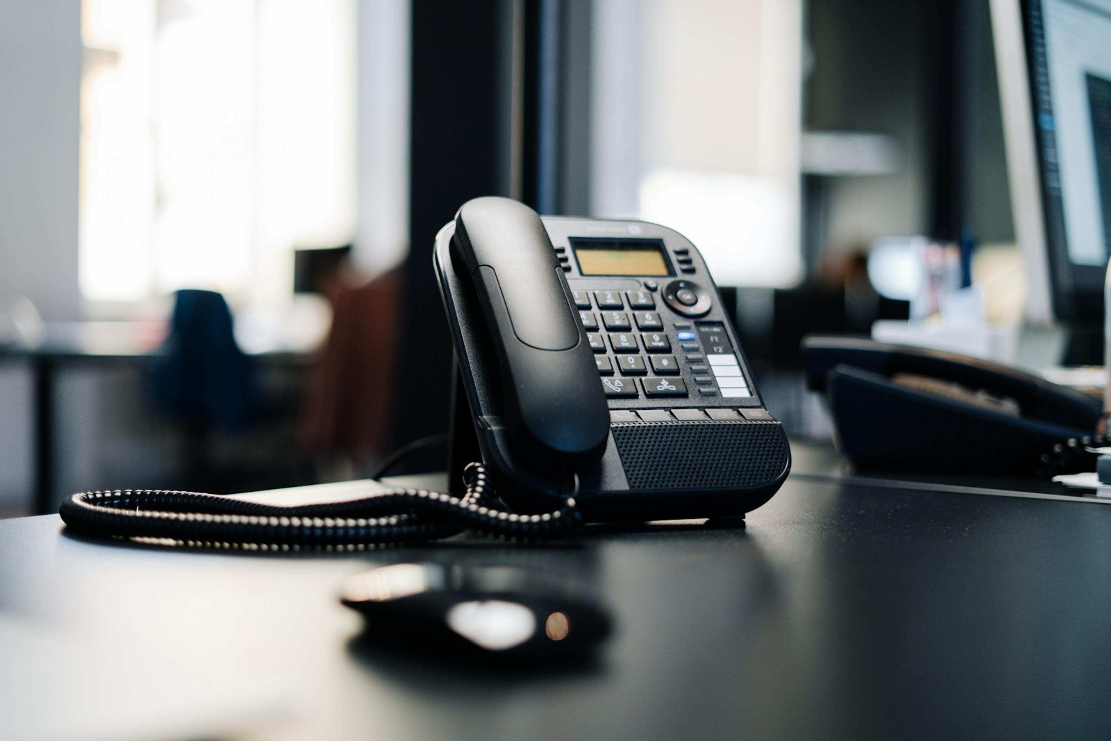 Black IP desk phone on an office desk