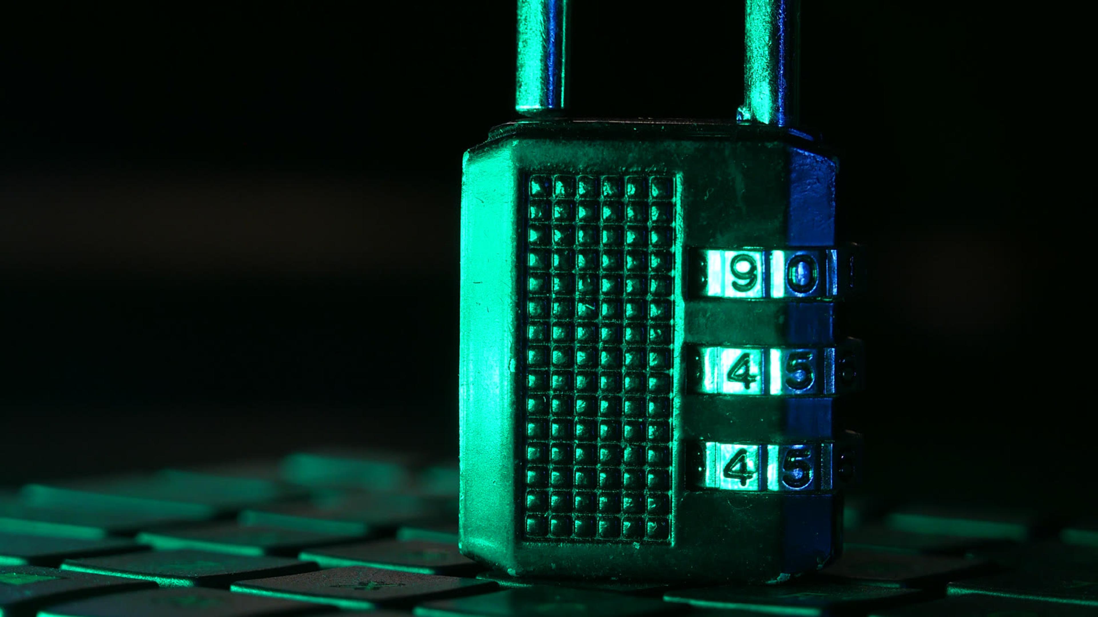 Combination padlock on a laptop keyboard — securing shared credentials in a company password vault