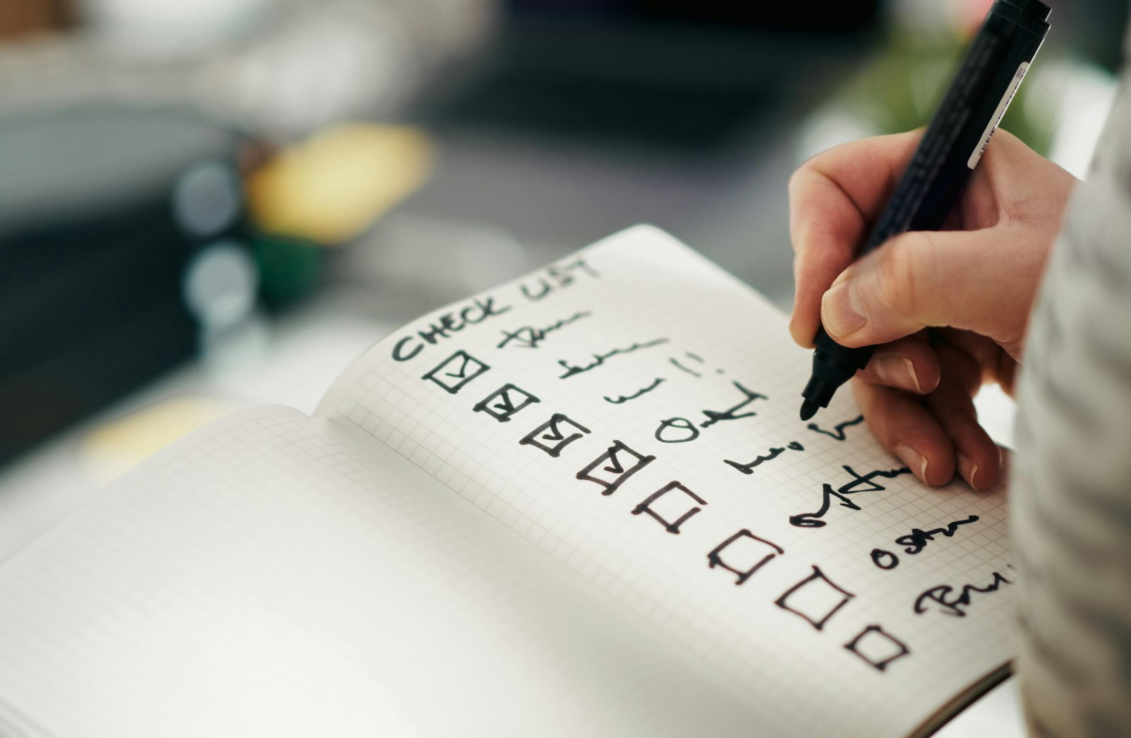 Person marking completed actions on a customer onboarding checklist