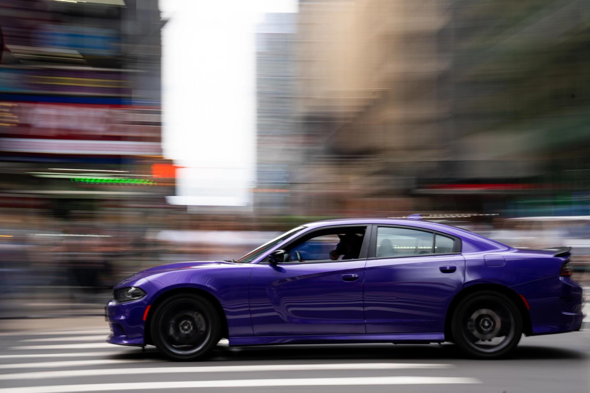 Purple Dodge Charger panned sharp against a blurred Manhattan street