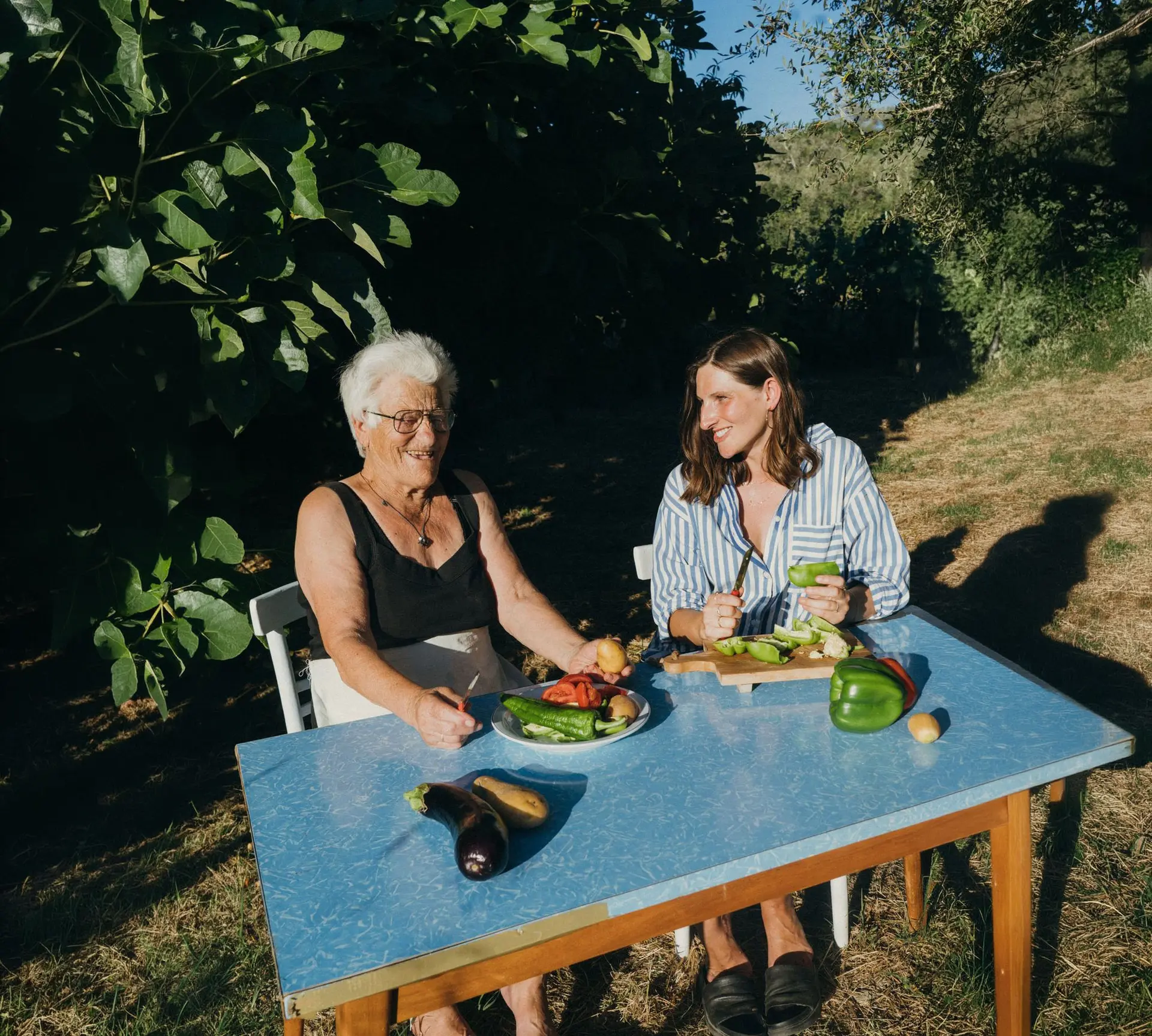 Zwei Frauen bereiten am Gartentisch Gemüse zu